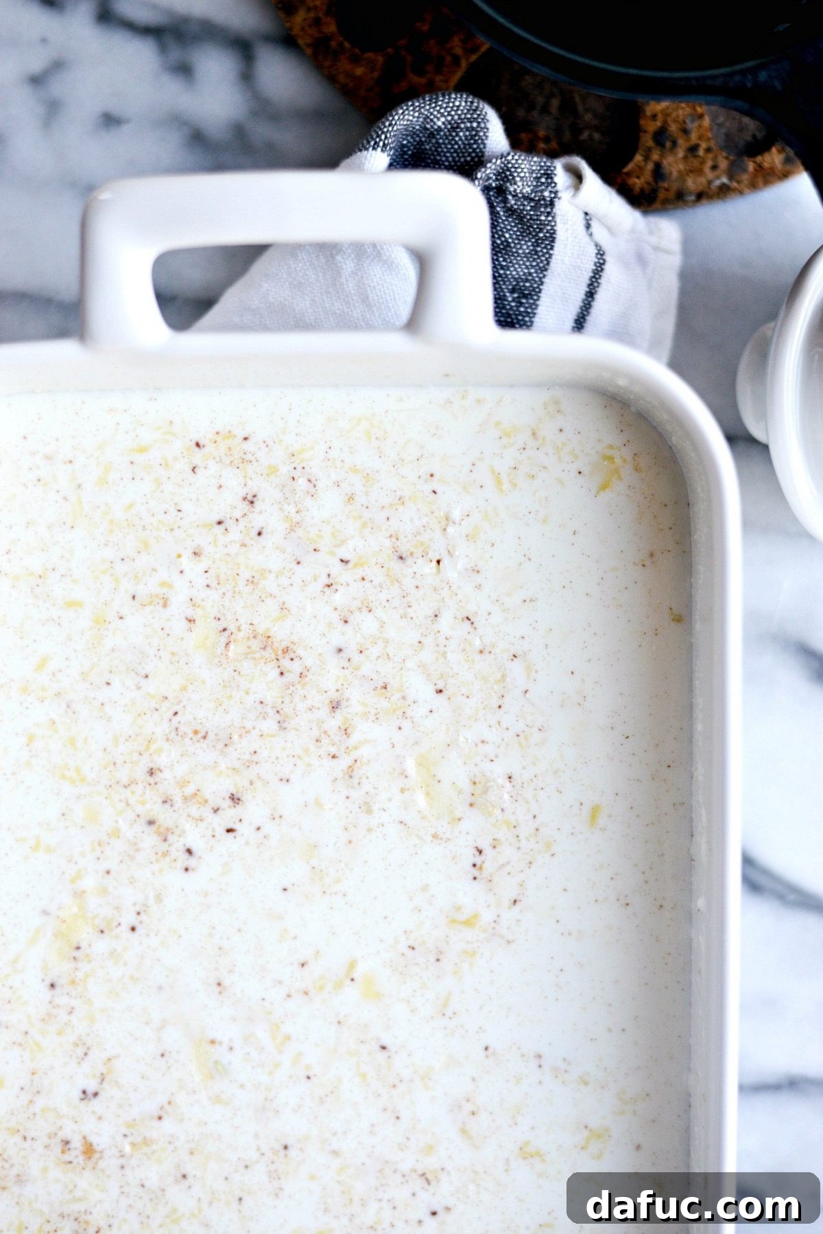 Pouring the rice pudding mixture into the buttered baking dish