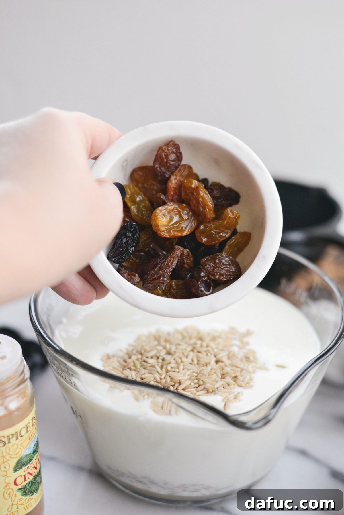 Adding a handful of raisins to the rice pudding mixture