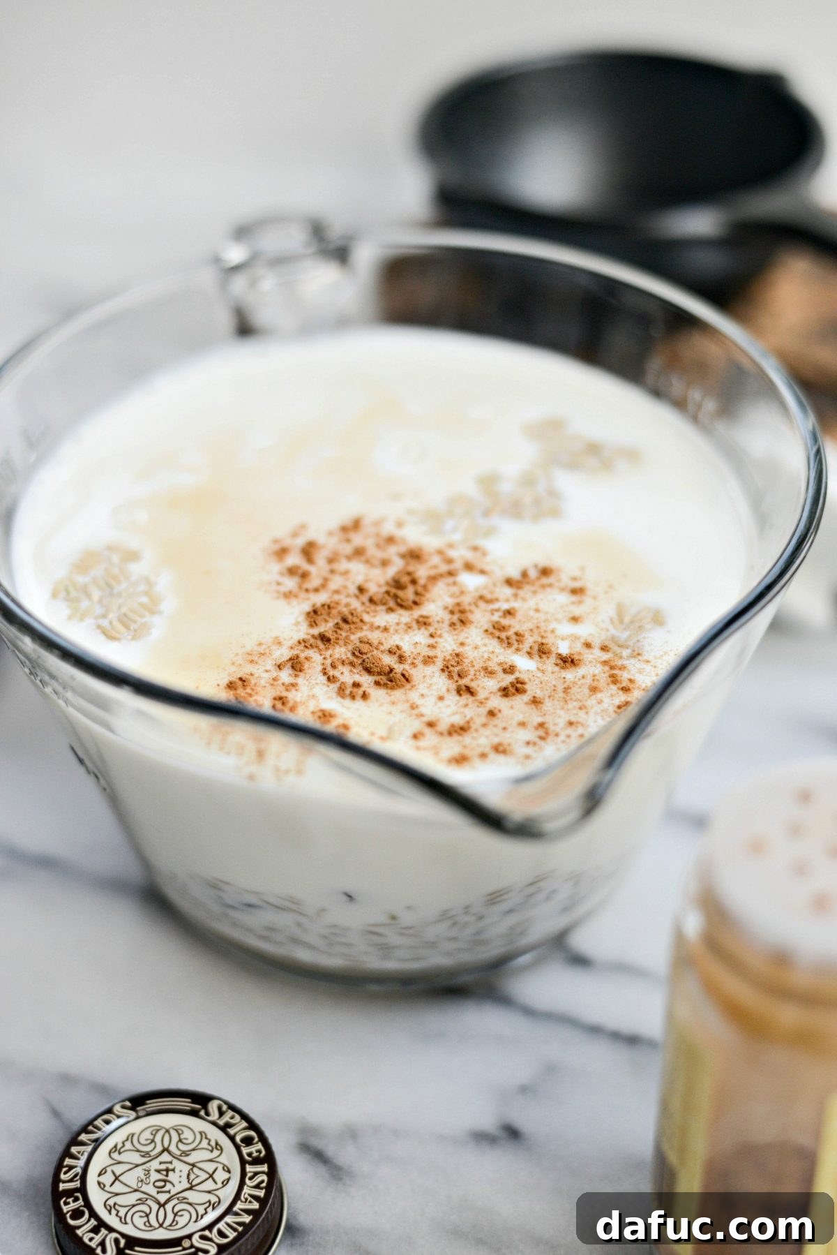 Sprinkling cinnamon into the rice pudding mixture