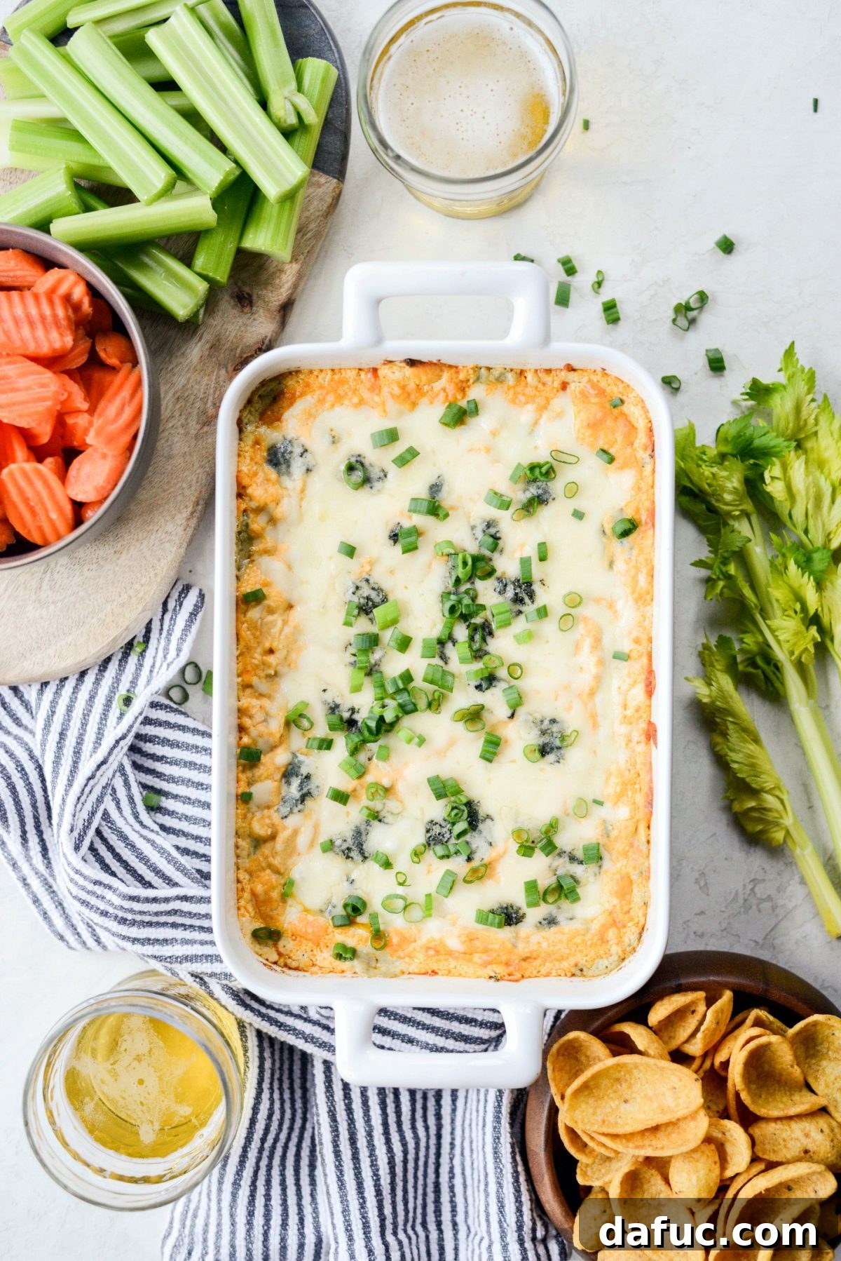 Best Baked Buffalo Chicken Dip served with Frito Scoops, celery, and carrots