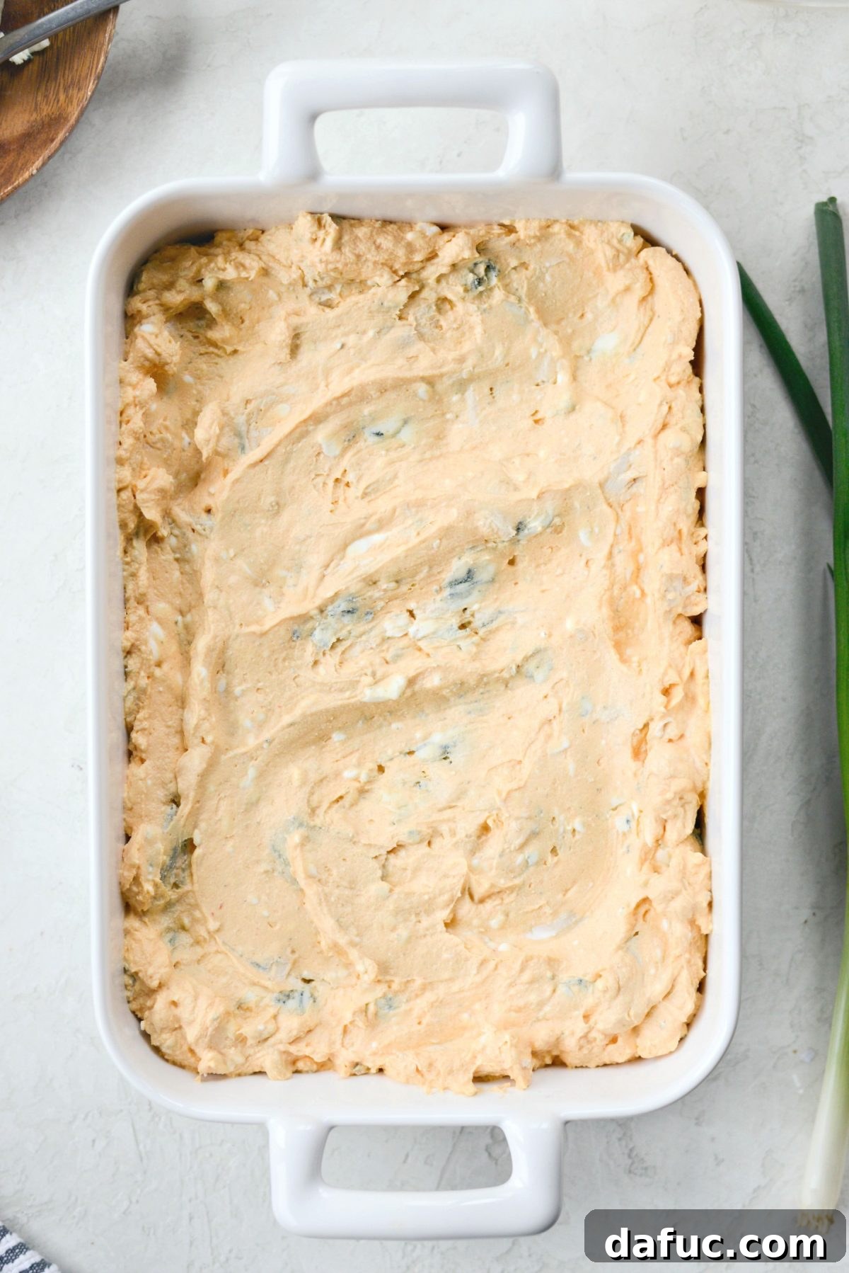 Spread the buffalo chicken dip mixture into a small oven-safe baking dish