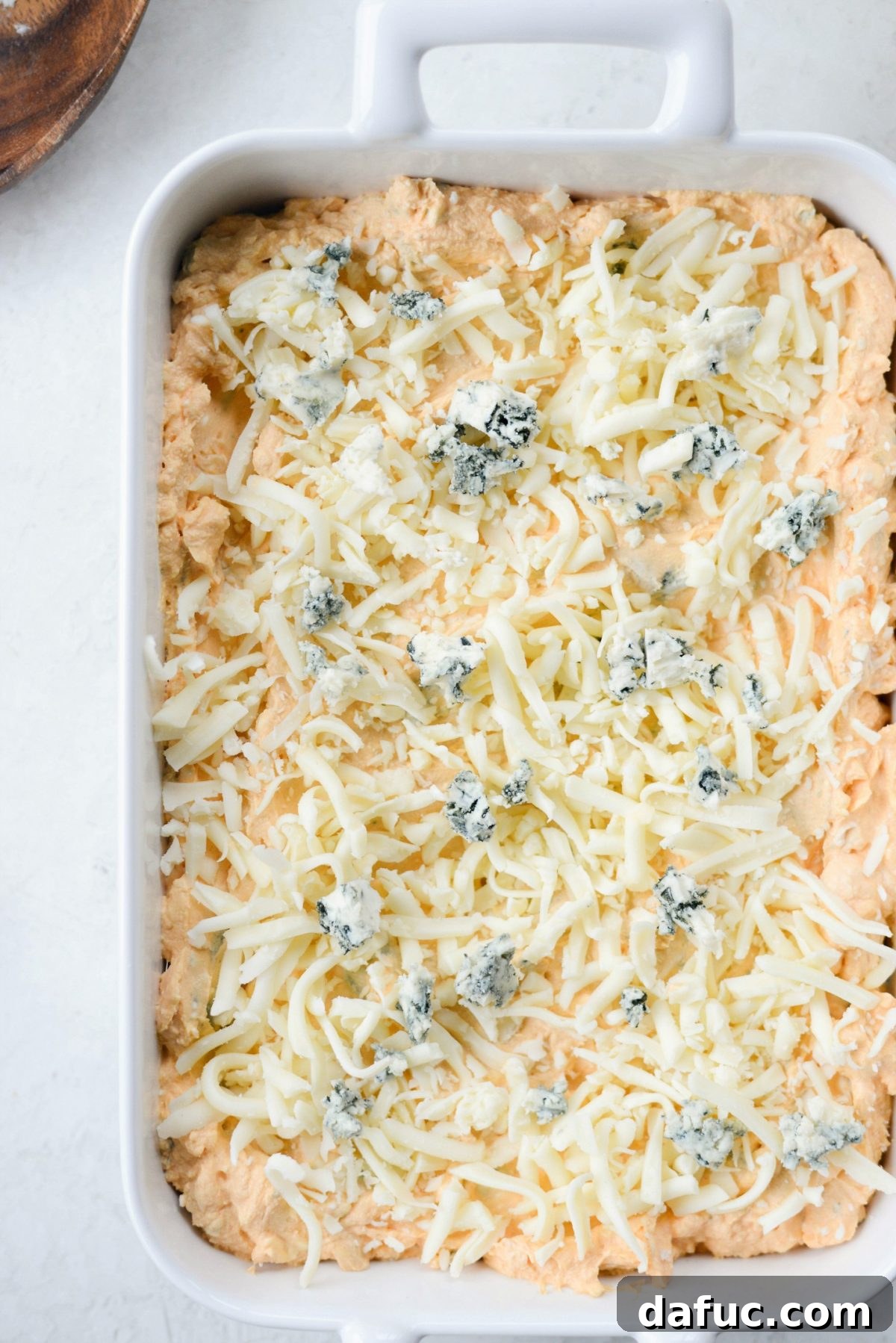 Top the buffalo chicken dip with shredded Monterey Jack cheese and extra blue cheese crumbles