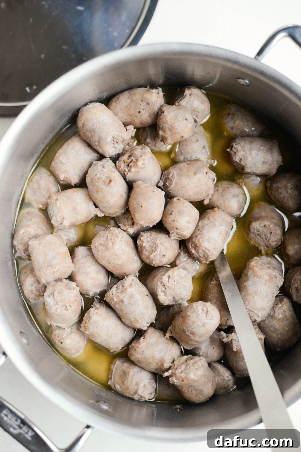 Wine-poached sausage bites ready for broiling