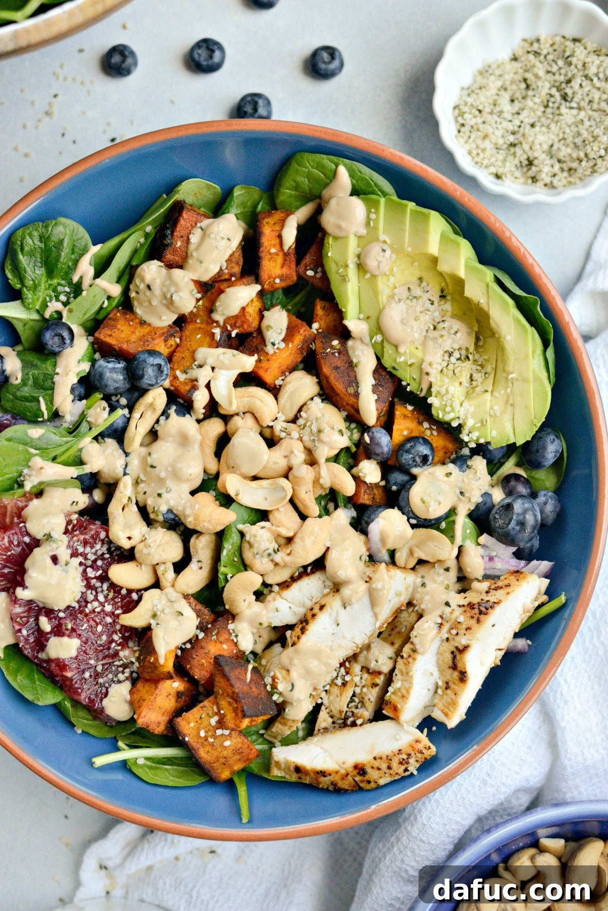 Sweet Potato Blueberry Radiance Bowl 2 A vibrant Sweet Potato Blueberry Power Bowl, bursting with colorful ingredients like roasted sweet potatoes, fresh blueberries, avocado, and blood oranges, drizzled with creamy cashew dressing.