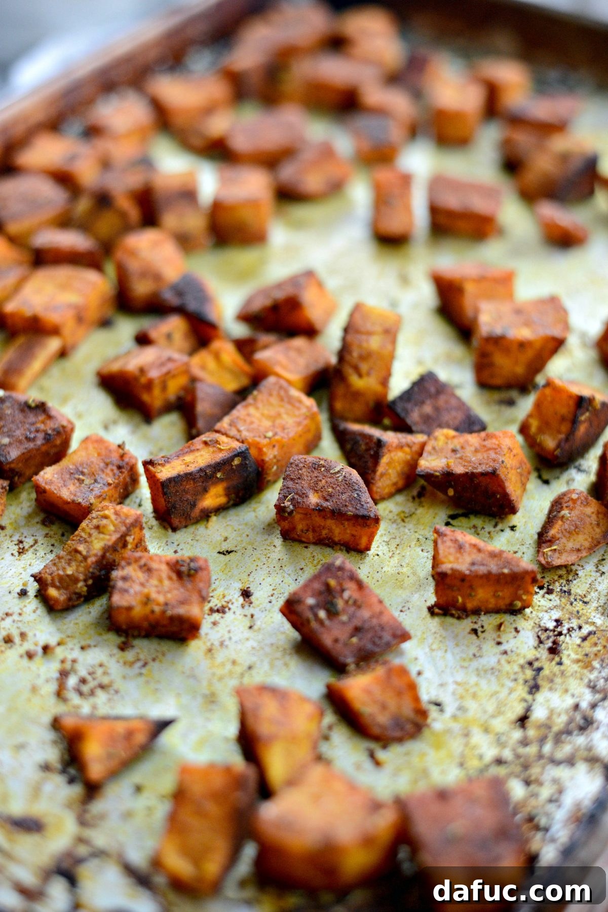 Sweet Potato Blueberry Radiance Bowl 6 Close-up of turmeric roasted sweet potatoes on a sheet pan, hot out of the oven.