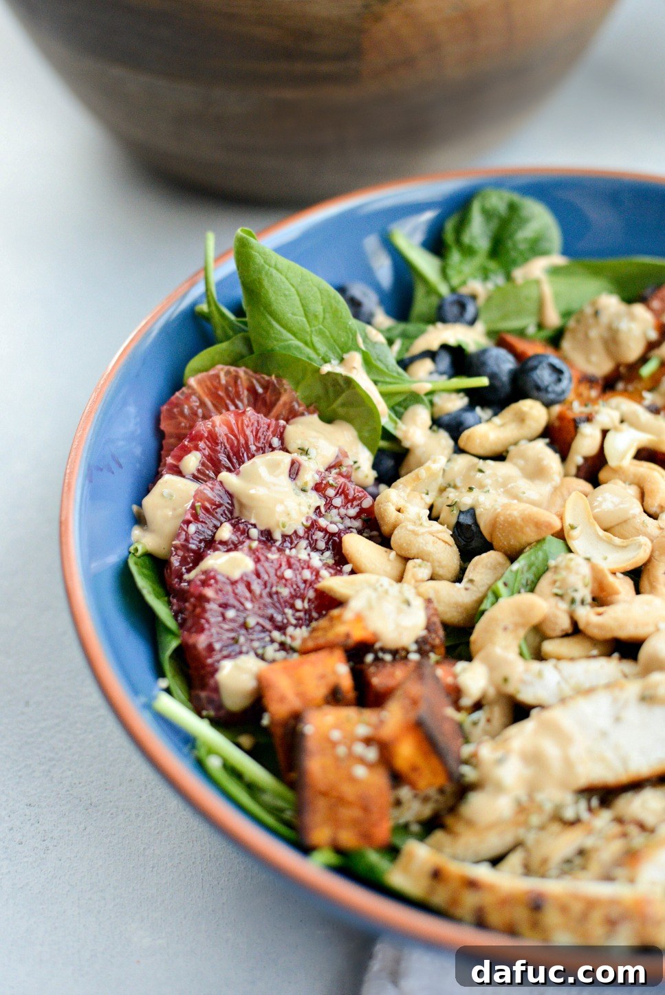 Sweet Potato Blueberry Radiance Bowl 8 Various fresh ingredients for the power bowl including sliced blood oranges, avocado, and spinach, alongside cooked chicken breast.