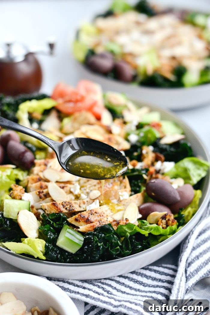 Drizzling Greek dressing over Modern Greek Kale Salad