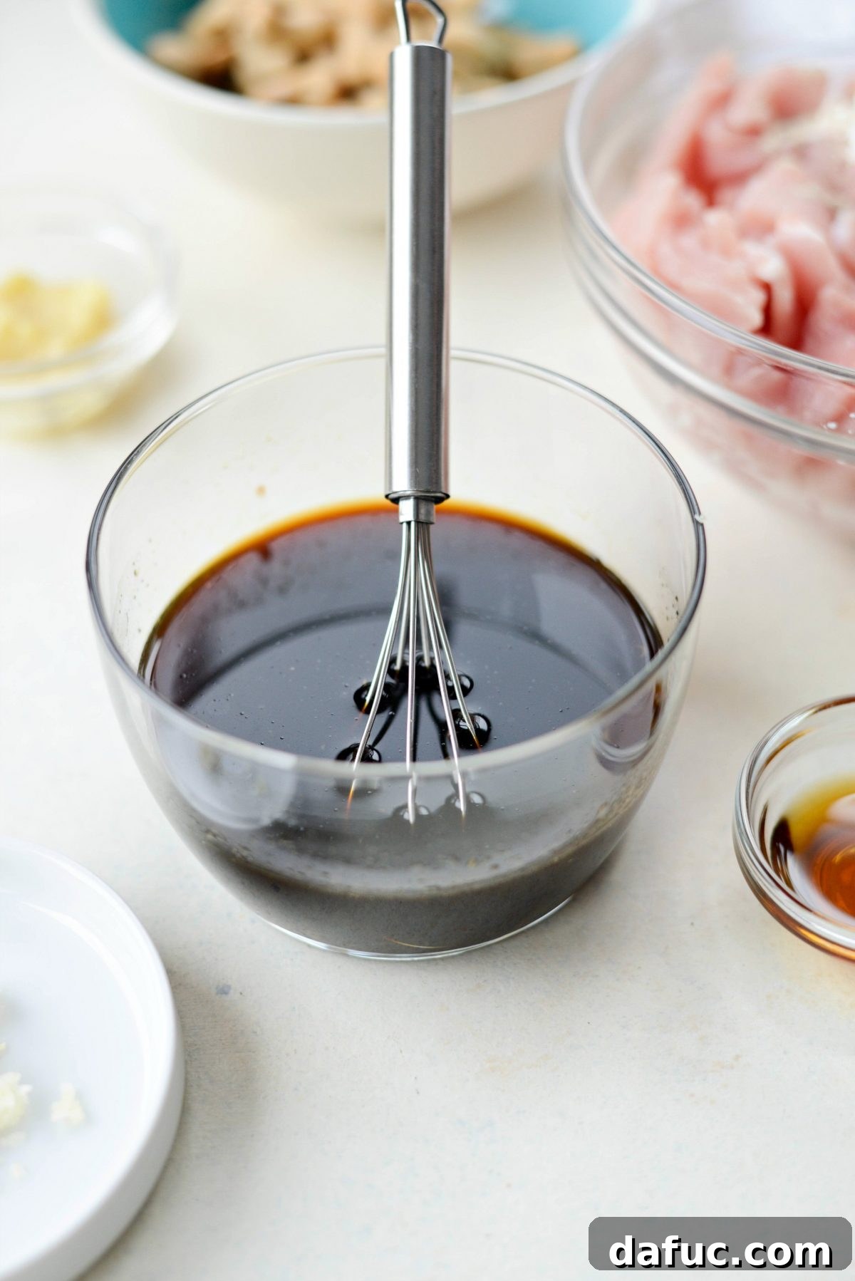 Mixing chili sauce, tamari, and lime juice in a bowl