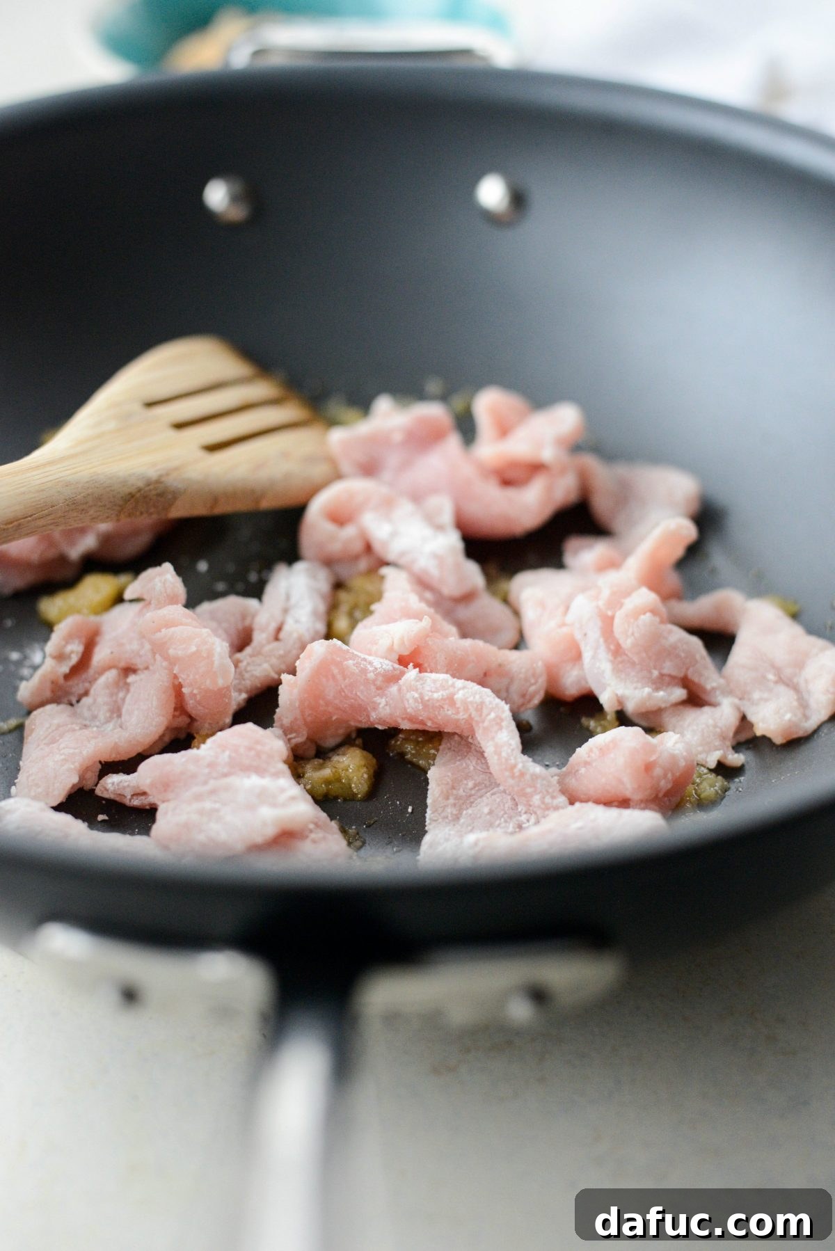 Crispy pork pieces cooking in a wok