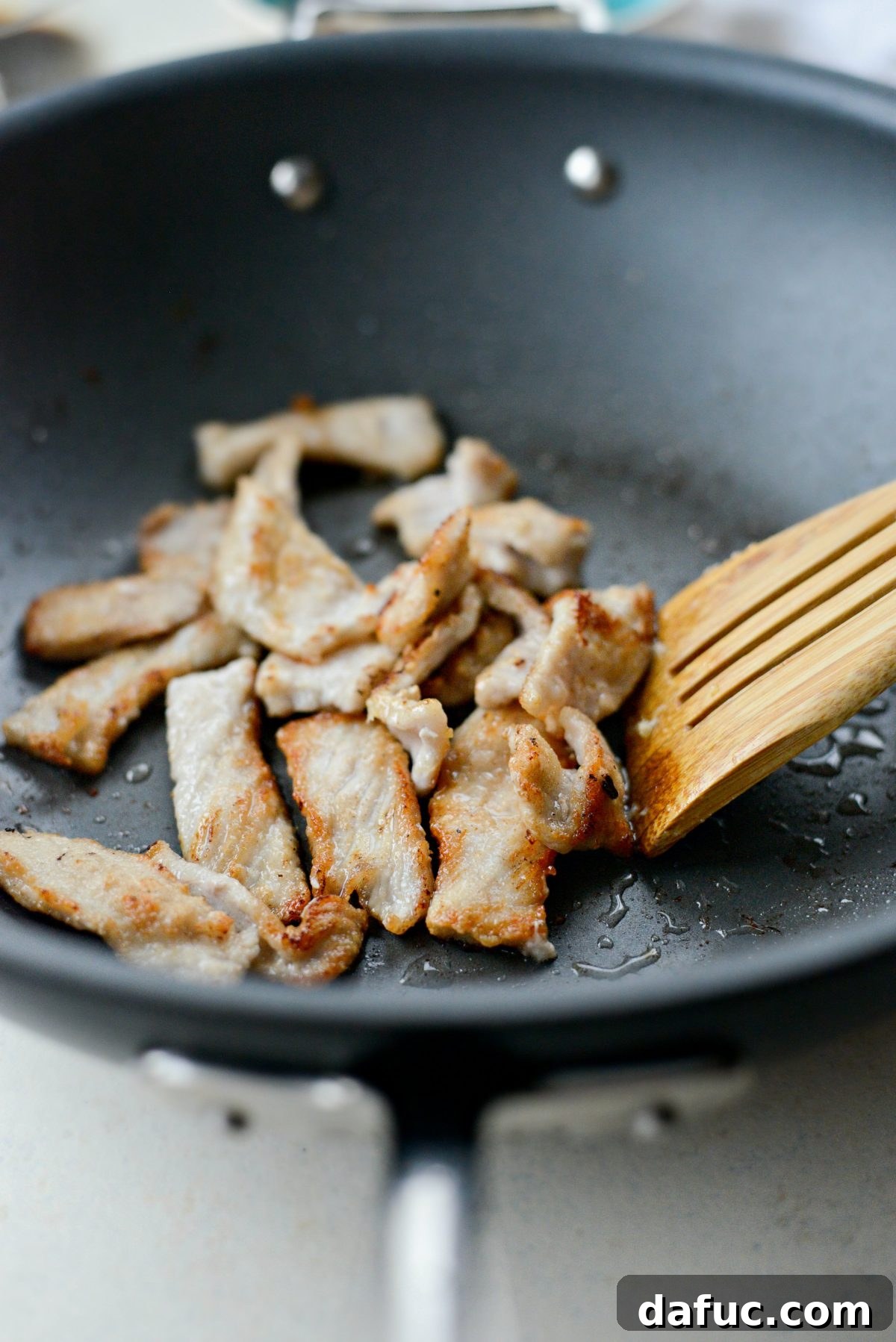 Close-up of crispy stir-fried pork in a wok