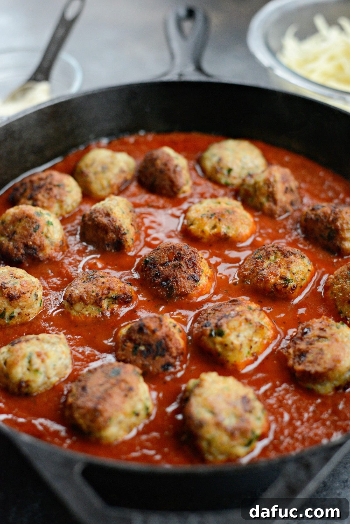 Chicken Parm Skillet Meatballs 14 Chicken parmesan meatballs nestled into marinara sauce in a skillet.