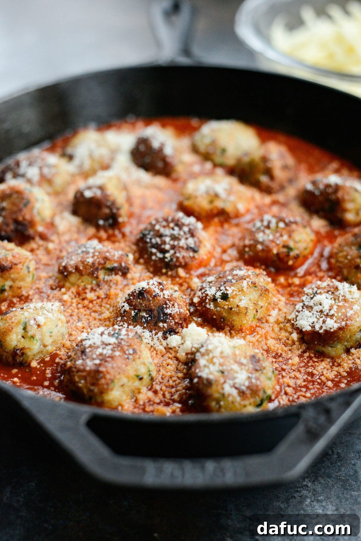 Chicken Parm Skillet Meatballs 15 Skillet chicken parmesan meatballs with a sprinkle of parmesan cheese on top.