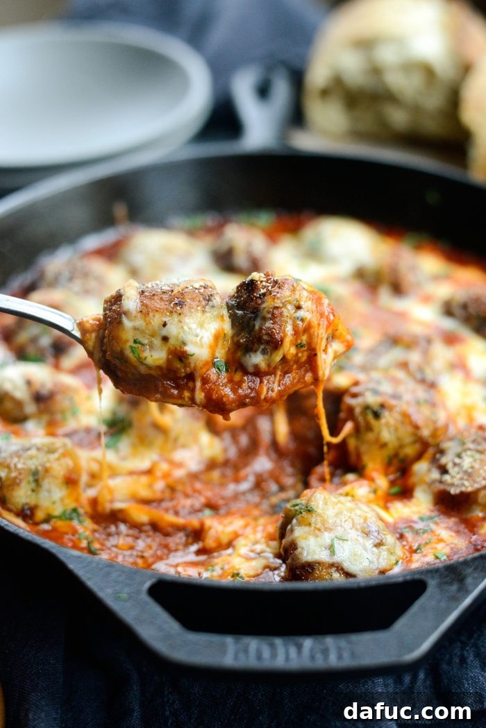 Chicken Parm Skillet Meatballs 19 A close-up of Skillet Chicken Parmesan Meatballs, glistening with sauce and melted cheese.