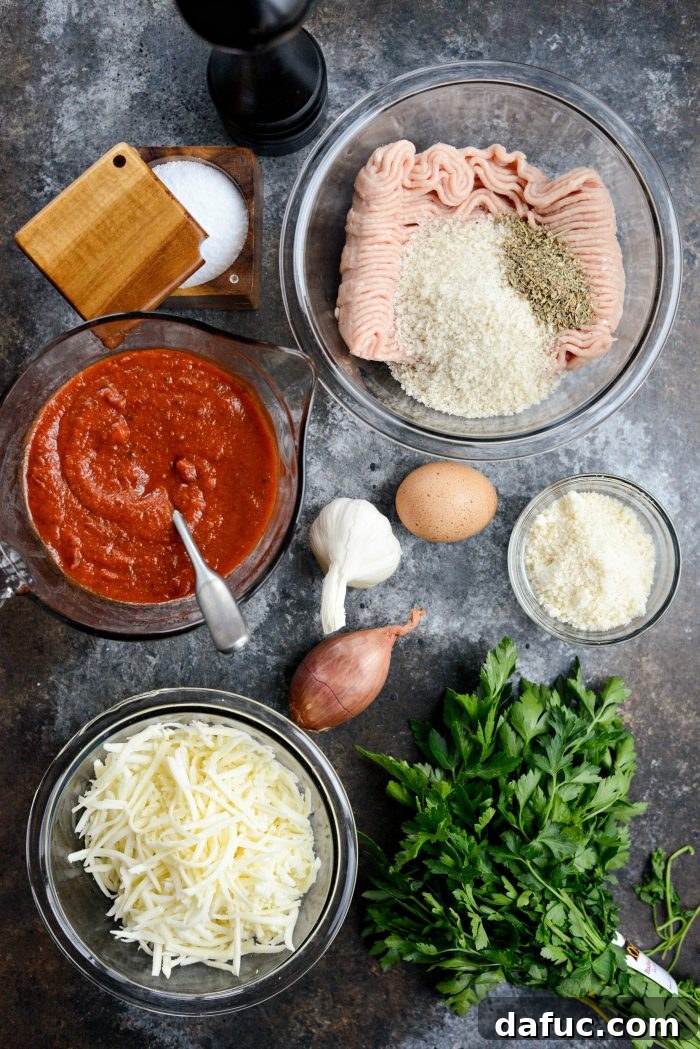 Chicken Parm Skillet Meatballs 4 Ingredients for Skillet Chicken Parmesan Meatballs laid out on a wooden board: ground chicken, breadcrumbs, cheese, herbs, and spices.