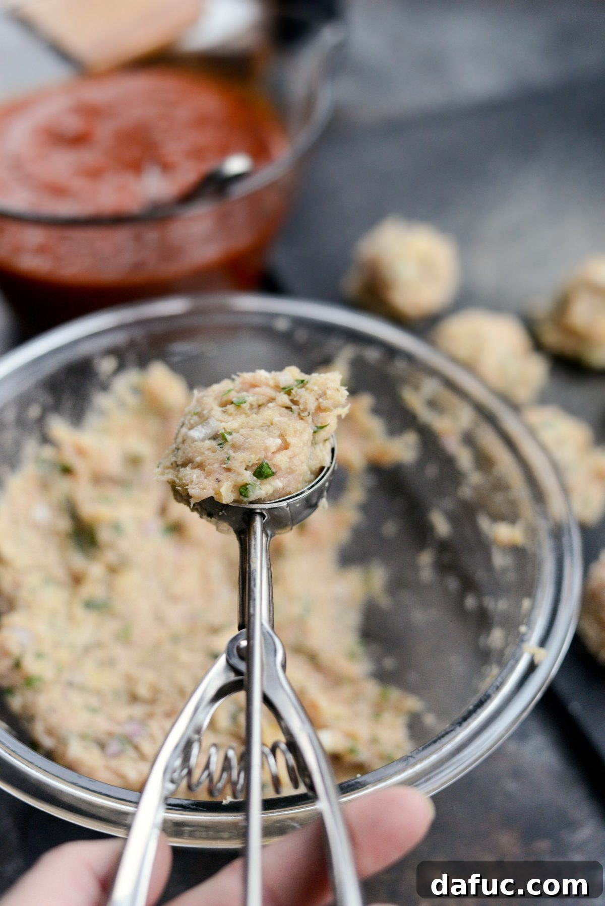 Chicken Parm Skillet Meatballs 9 Scooping out portions of the chicken meatball mixture with a 2-tablespoon scoop.