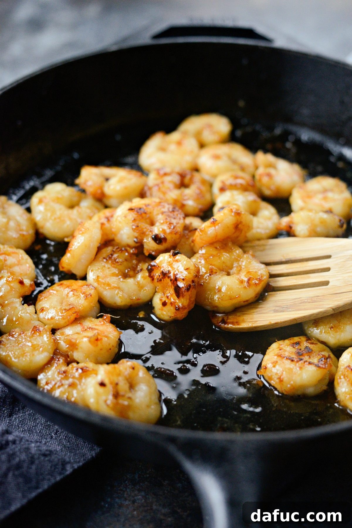 Cooking and caramelizing Glazed Hot Honey Garlic Shrimp in a pan