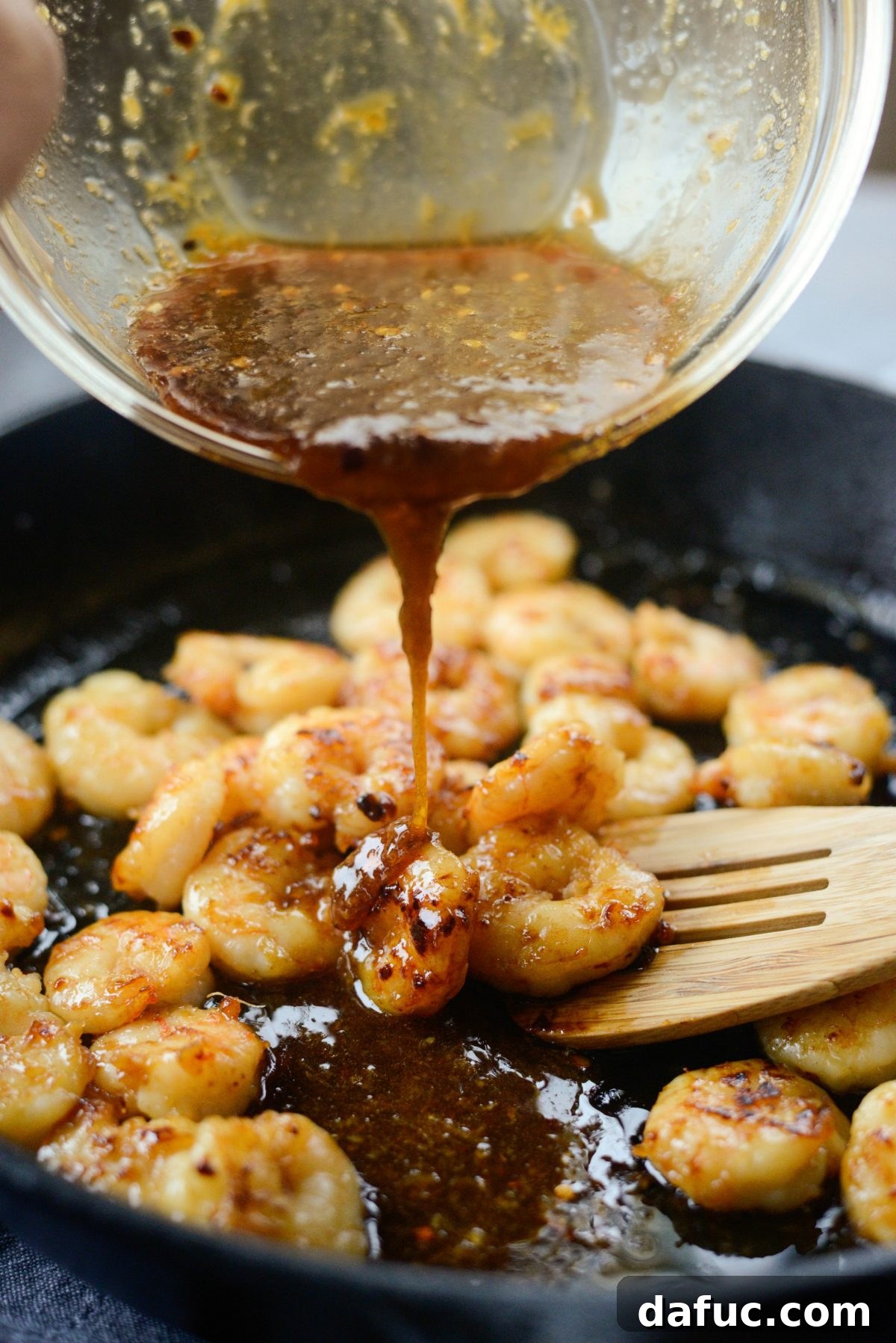 Pouring remaining sauce over perfectly cooked Glazed Hot Honey Garlic Shrimp