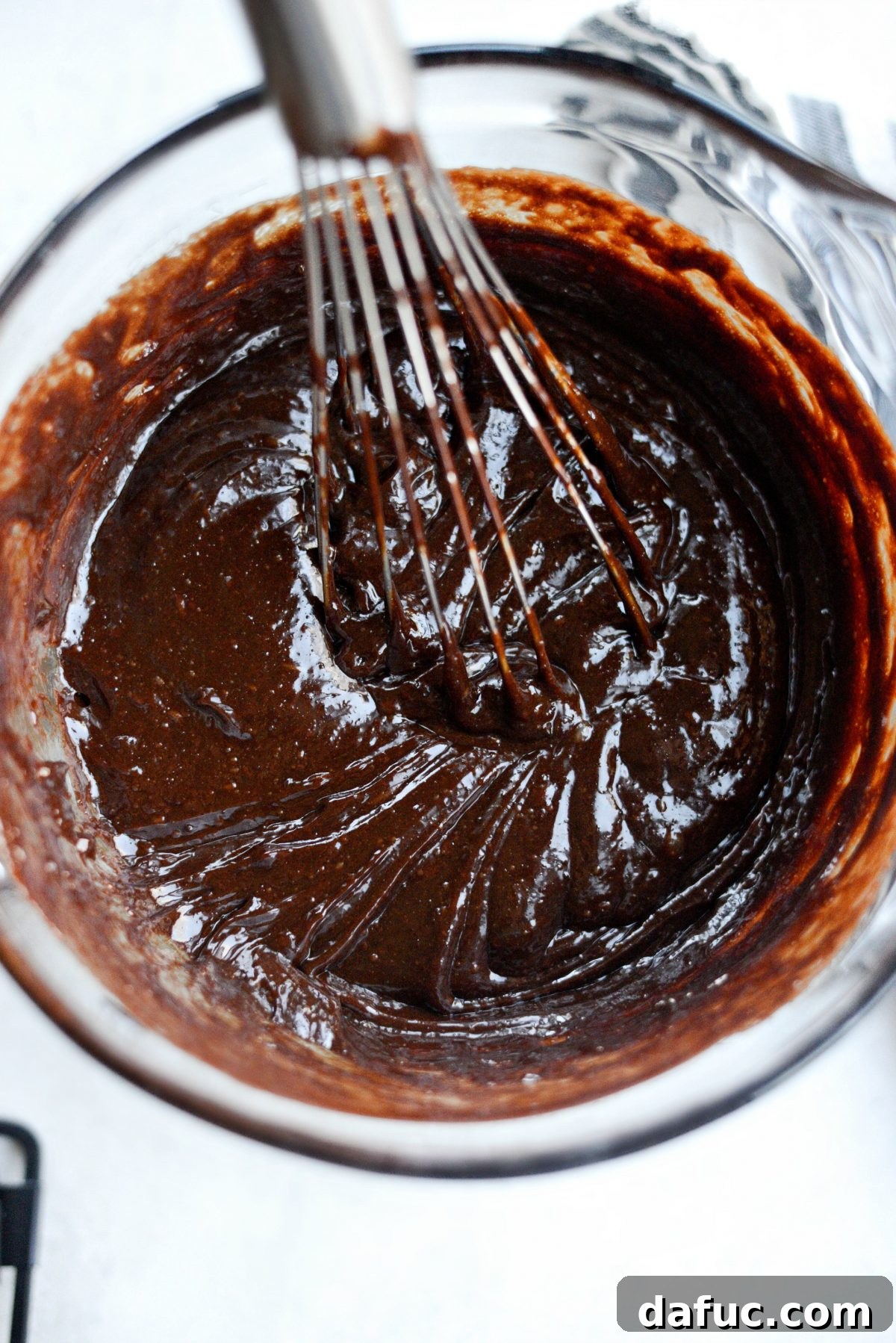 Smooth, glossy brownie batter in a mixing bowl after all wet ingredients are combined