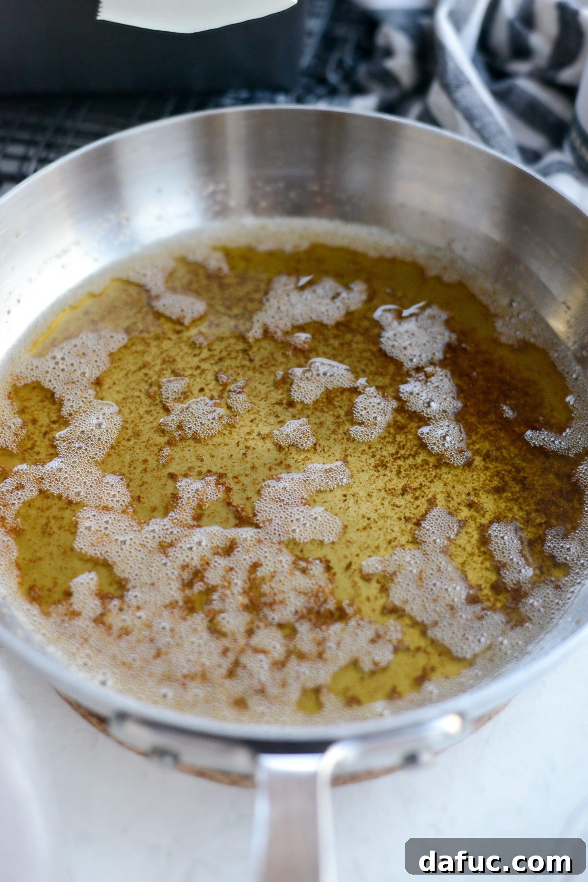 Unsalted butter browning in a skillet over medium-low heat, showing a golden color