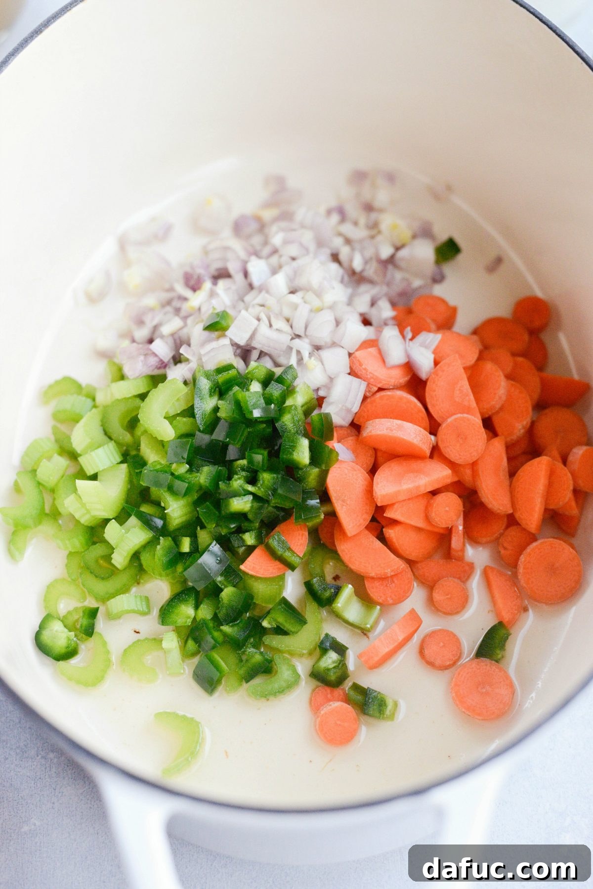 Ingredients for Irish Cheddar Beer Soup laid out: fresh vegetables, thyme, garlic, bay leaves, and cheese.