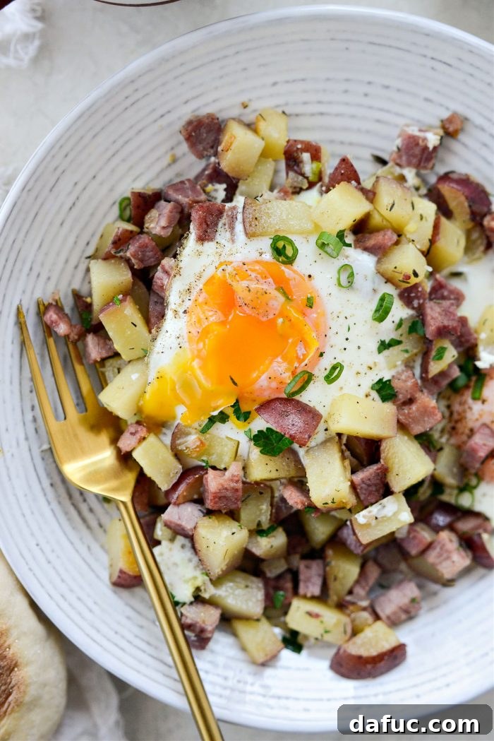 Close-up of freshly cooked corned beef hash with eggs, ready to be served.