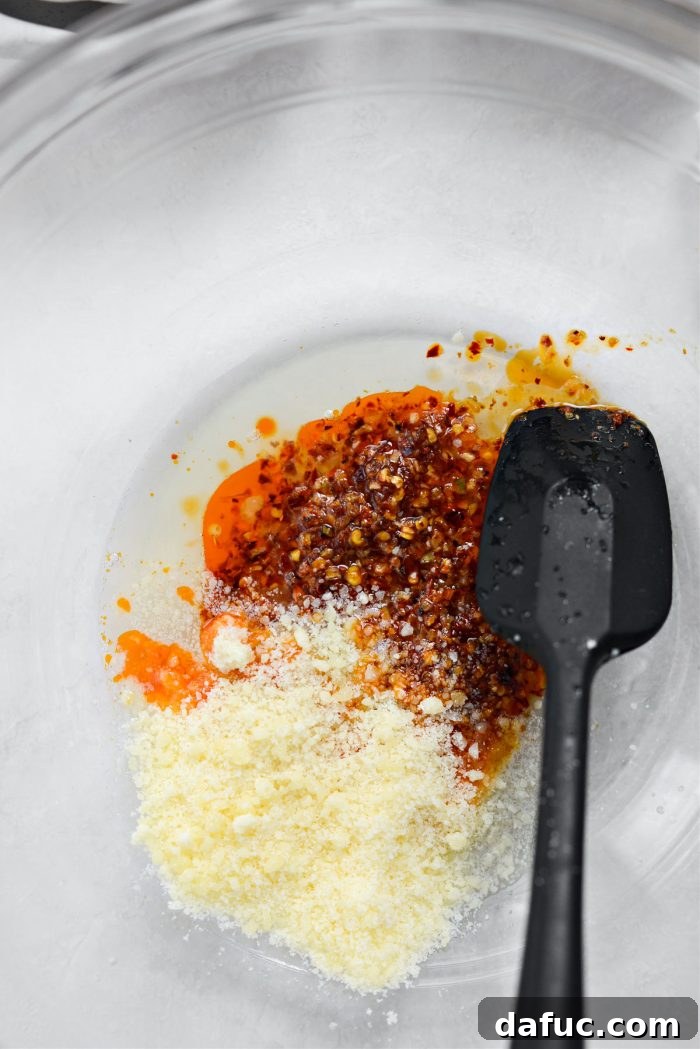 Parmesan cheese, chili garlic oil, and lemon juice in a bowl