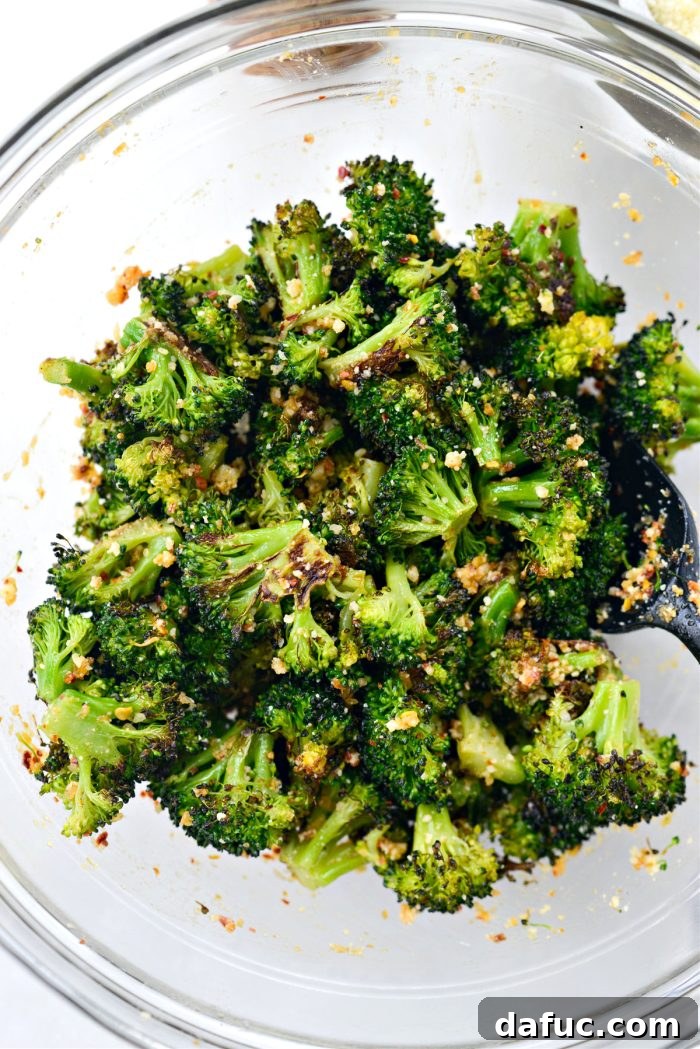 Tossing roasted broccoli with the chili garlic and Parmesan dressing