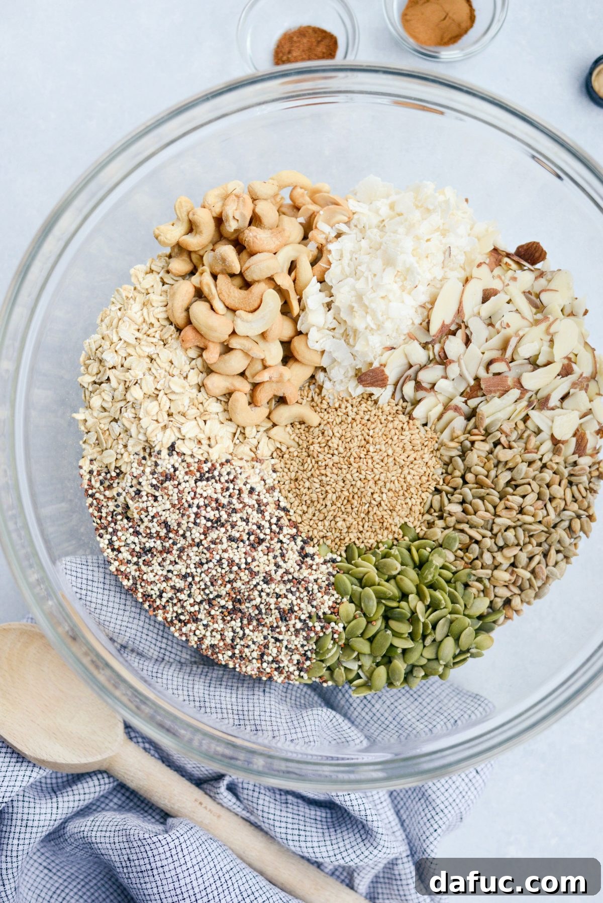 Add oats, nuts, and seeds to a large mixing bowl