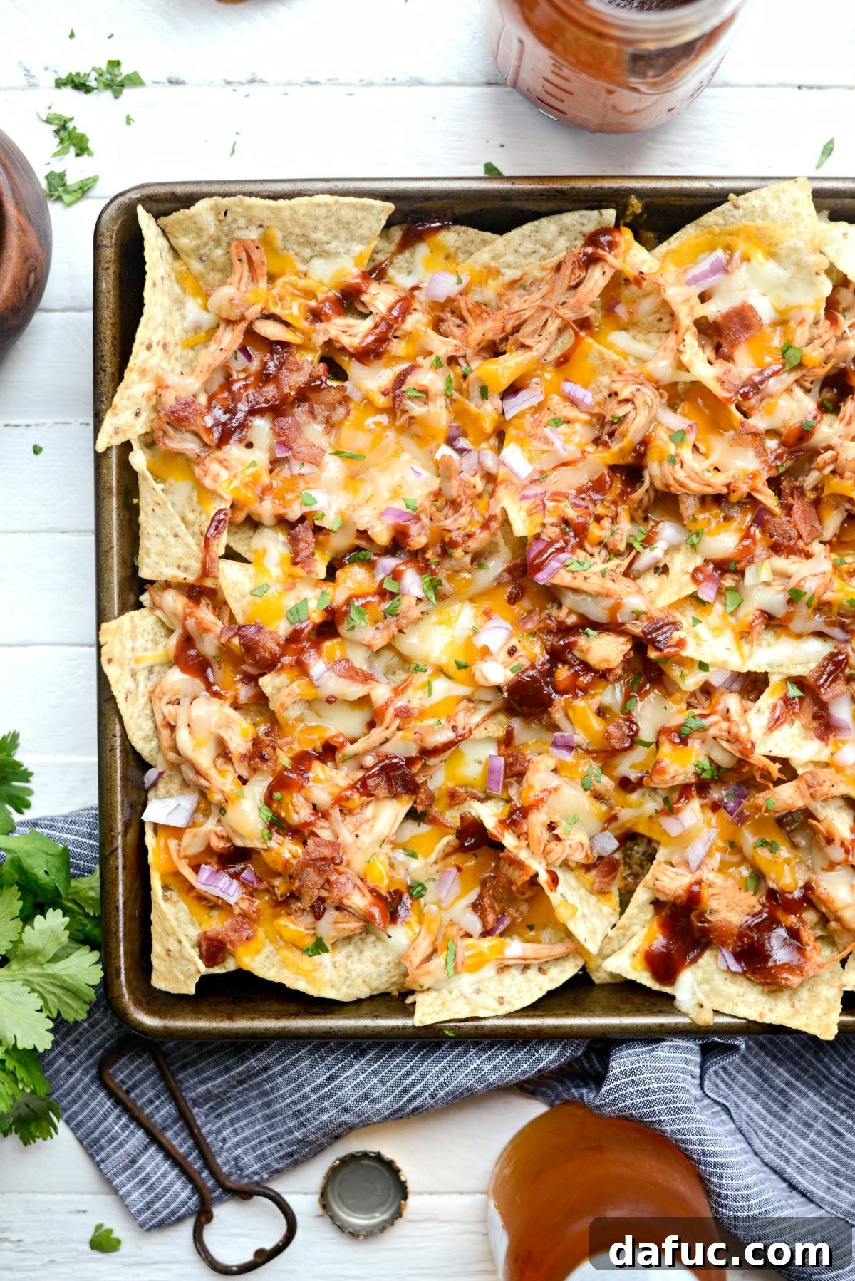 Close-up of Sheet Pan BBQ Chicken Nachos with melted cheese and fresh cilantro.