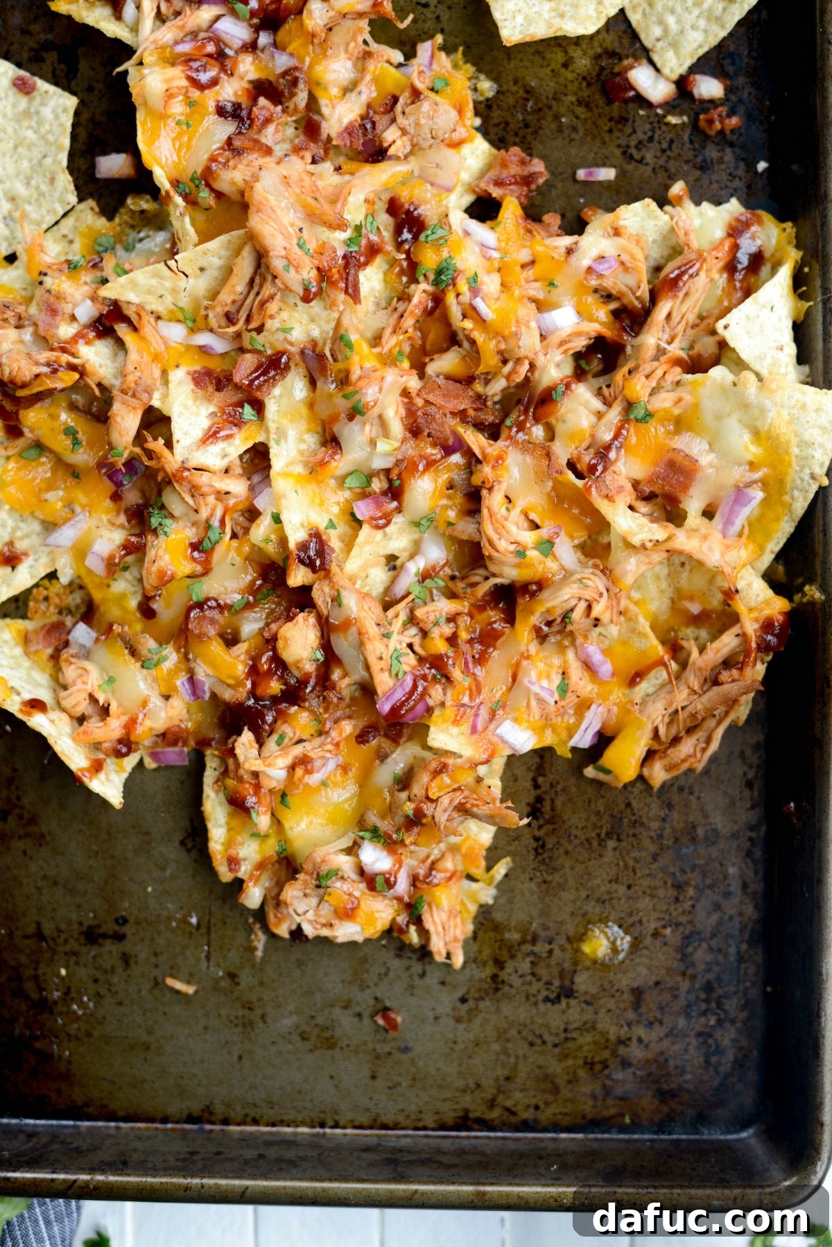 A final close-up shot of Sheet Pan BBQ Chicken Nachos on a baking sheet.
