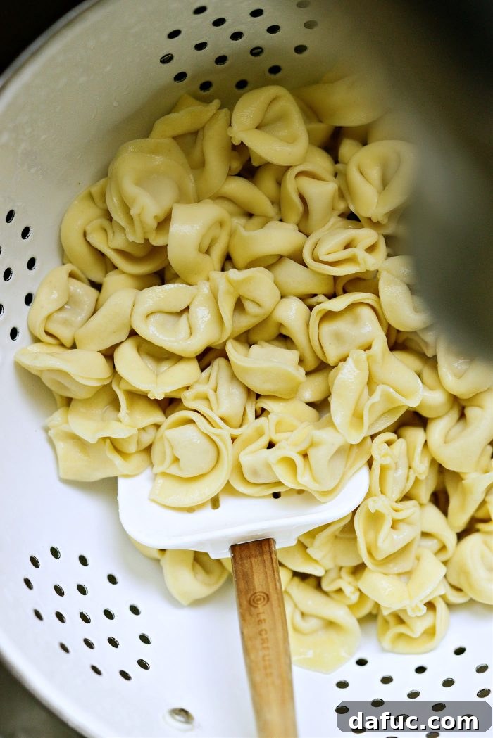 Drained and rinsed tortellini in a colander under cold water