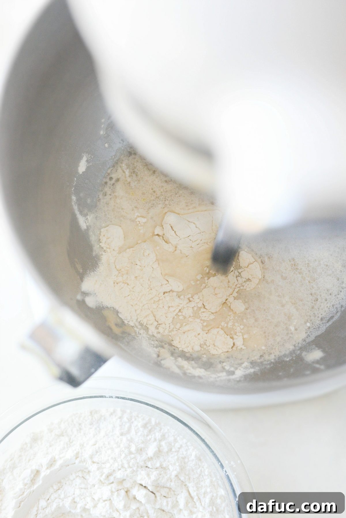 Mastering Homemade Pizza Dough 9 Gradually adding flour to dough mixture in stand mixer