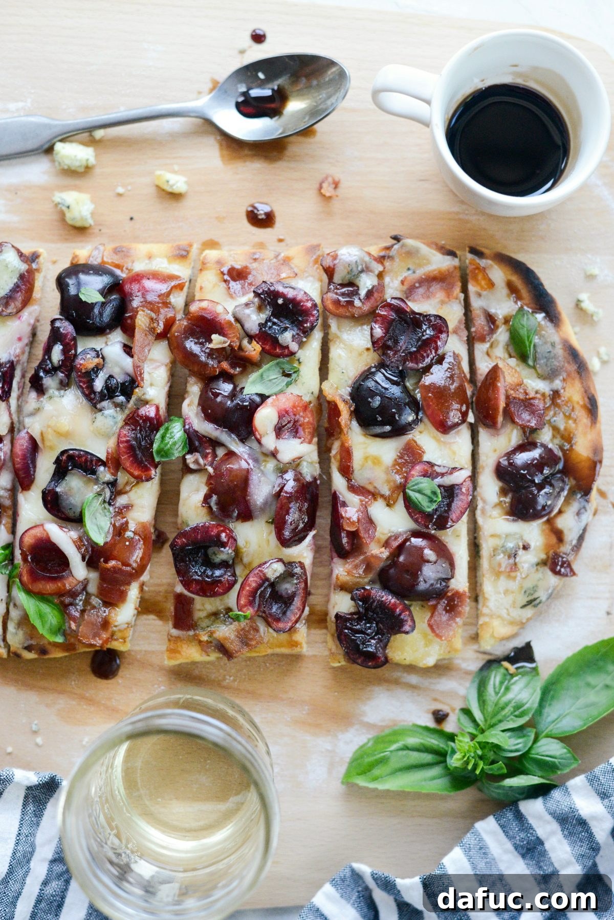 Closeup of a slice of Grilled Cherry Gorgonzola Flatbread Pizza with basil