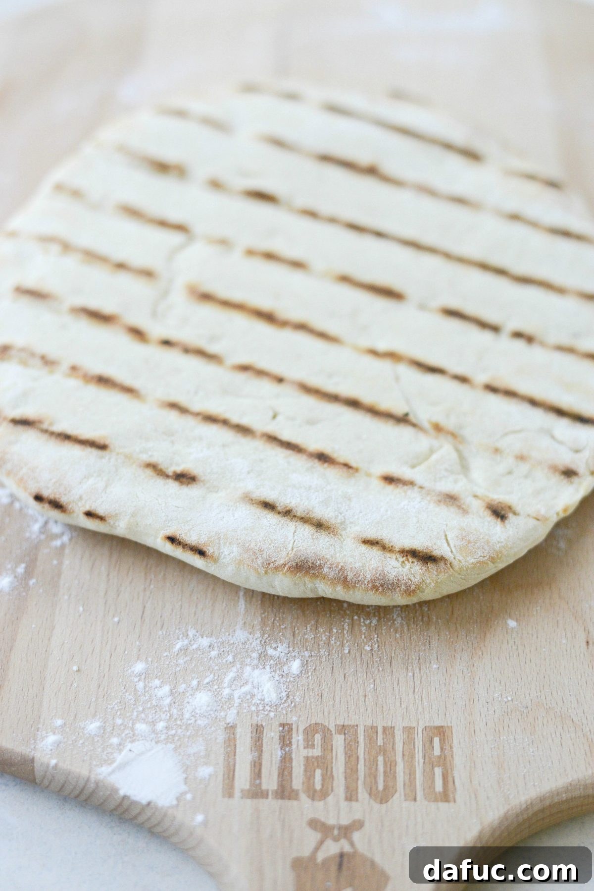 Grilled pizza dough with golden grill marks