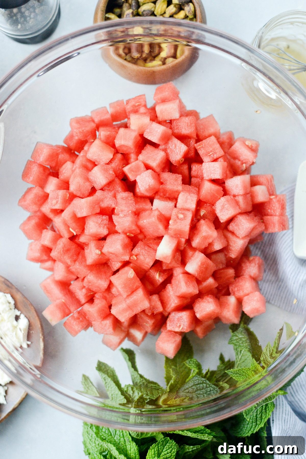 Cubed seedless watermelon in a large mixing bowl, ready for salad assembly.