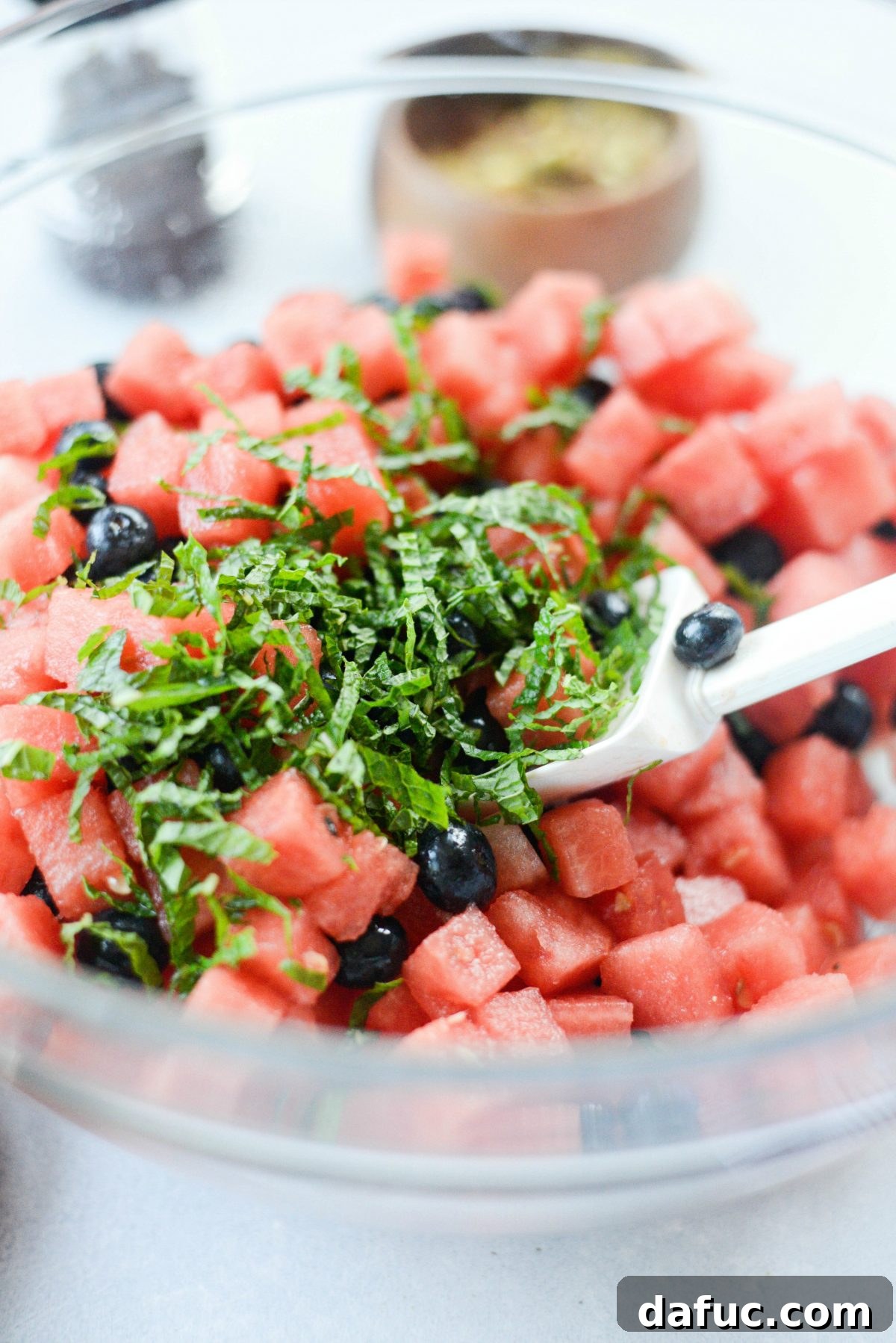 Adding thinly sliced fresh mint to the watermelon and blueberry salad.