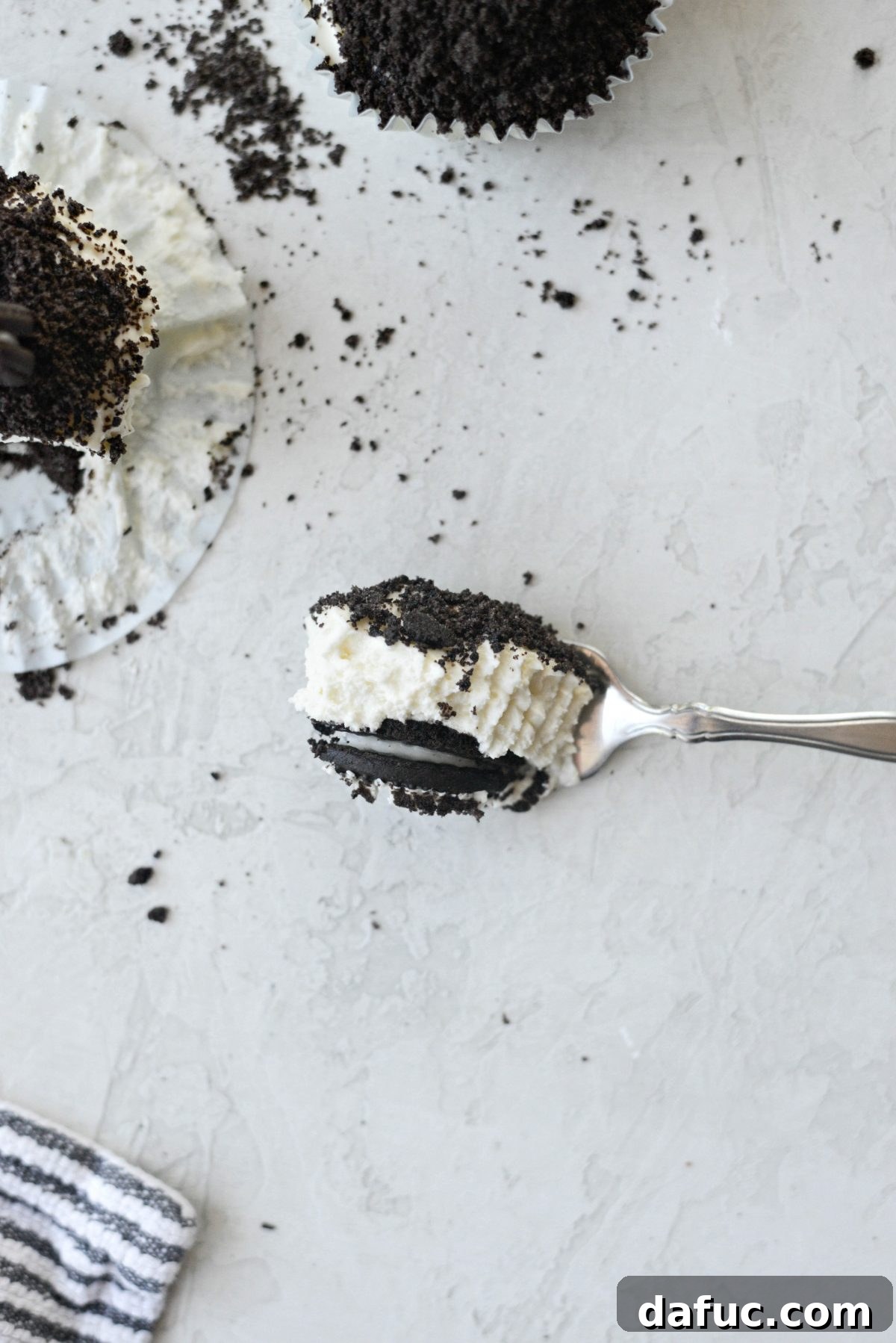 Decadent No-Bake Cookies and Cream Cheesecake Bites 21 Close-up shot of a No-Bake Cookies and Cream Mini Cheesecake with a portion taken out, revealing the creamy interior and cookie base