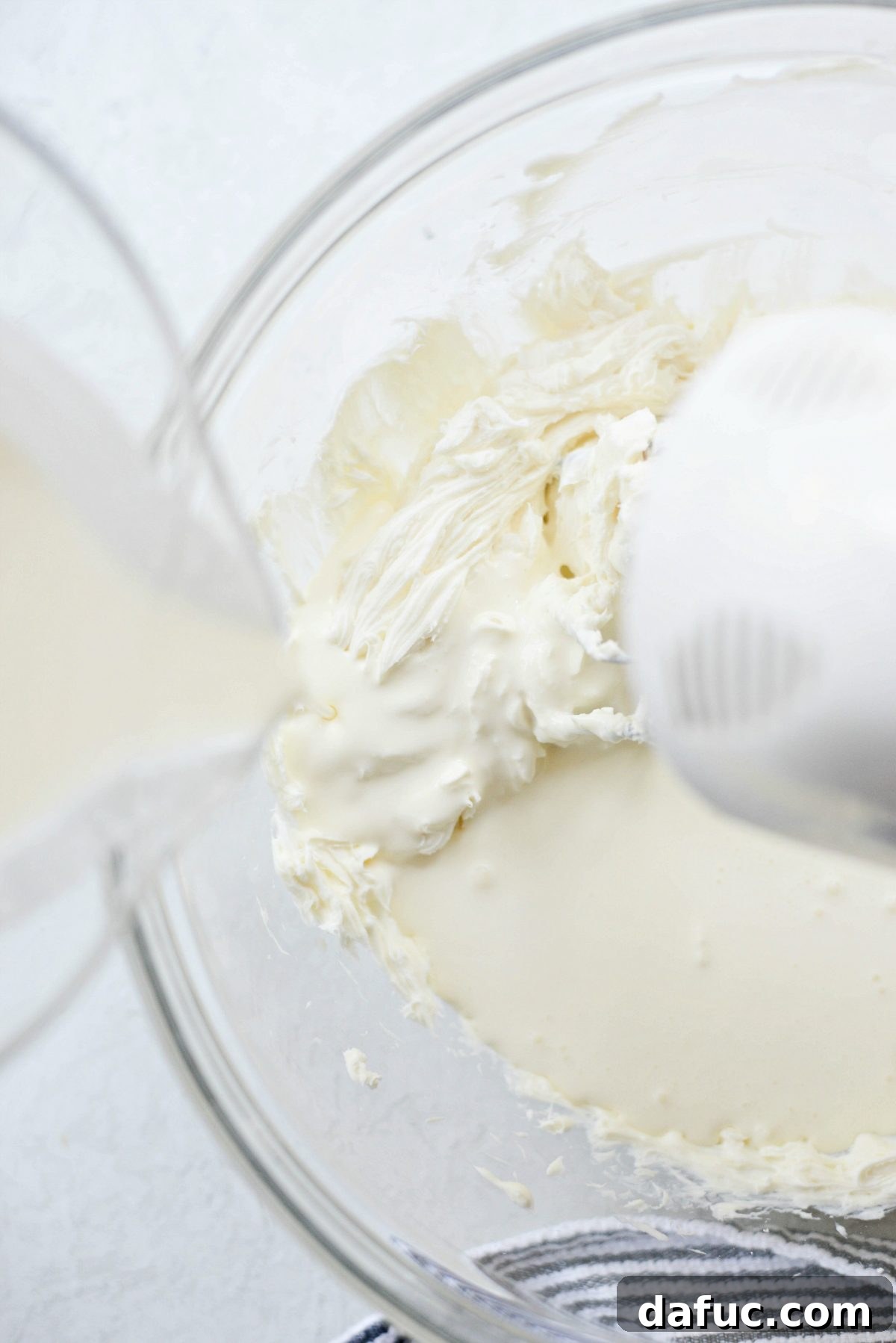 Decadent No-Bake Cookies and Cream Cheesecake Bites 8 Slowly pouring cold heavy cream into the smooth cream cheese base while mixing on low speed