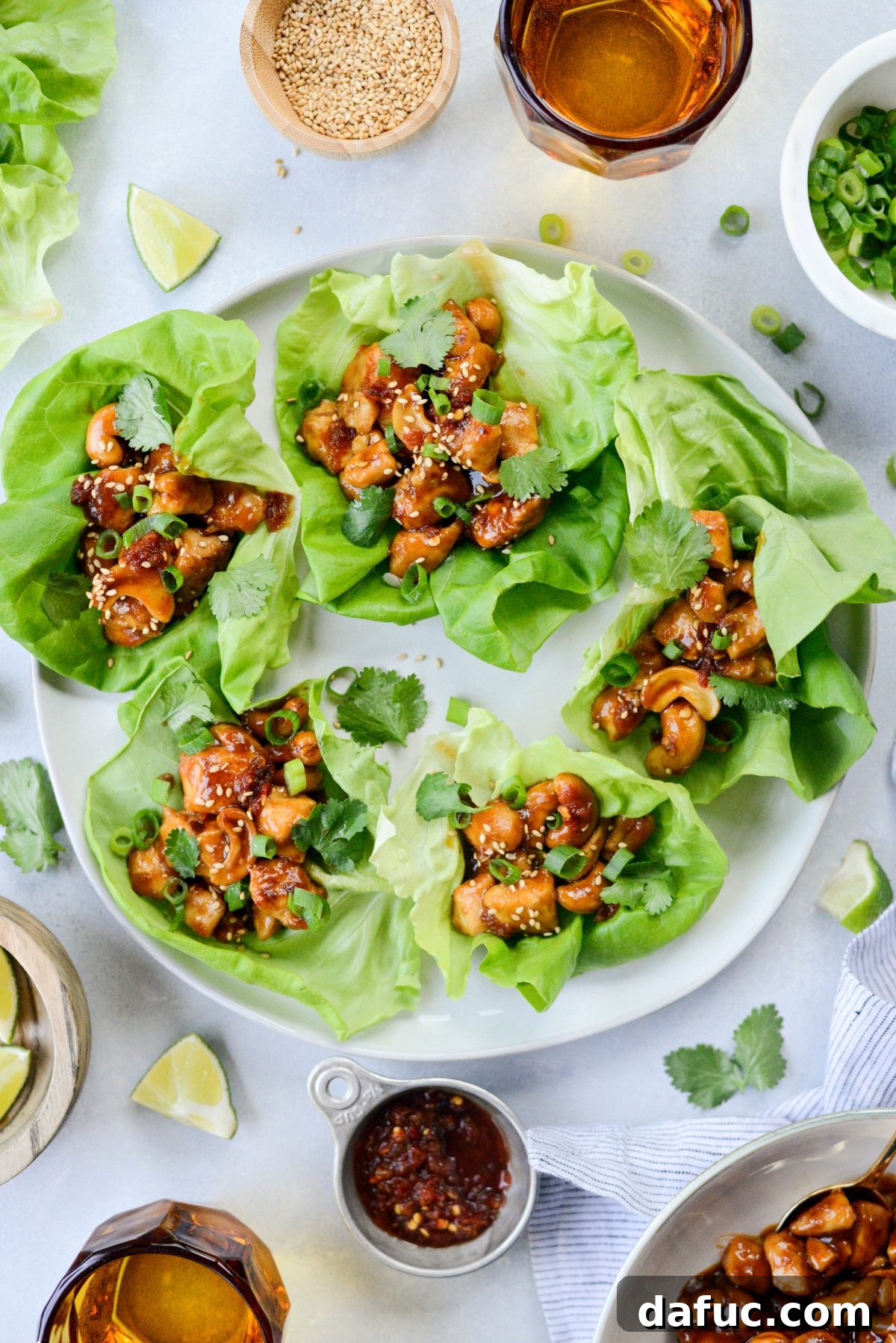 Plating Thai Cashew Chicken Lettuce Wraps with fresh garnishes.