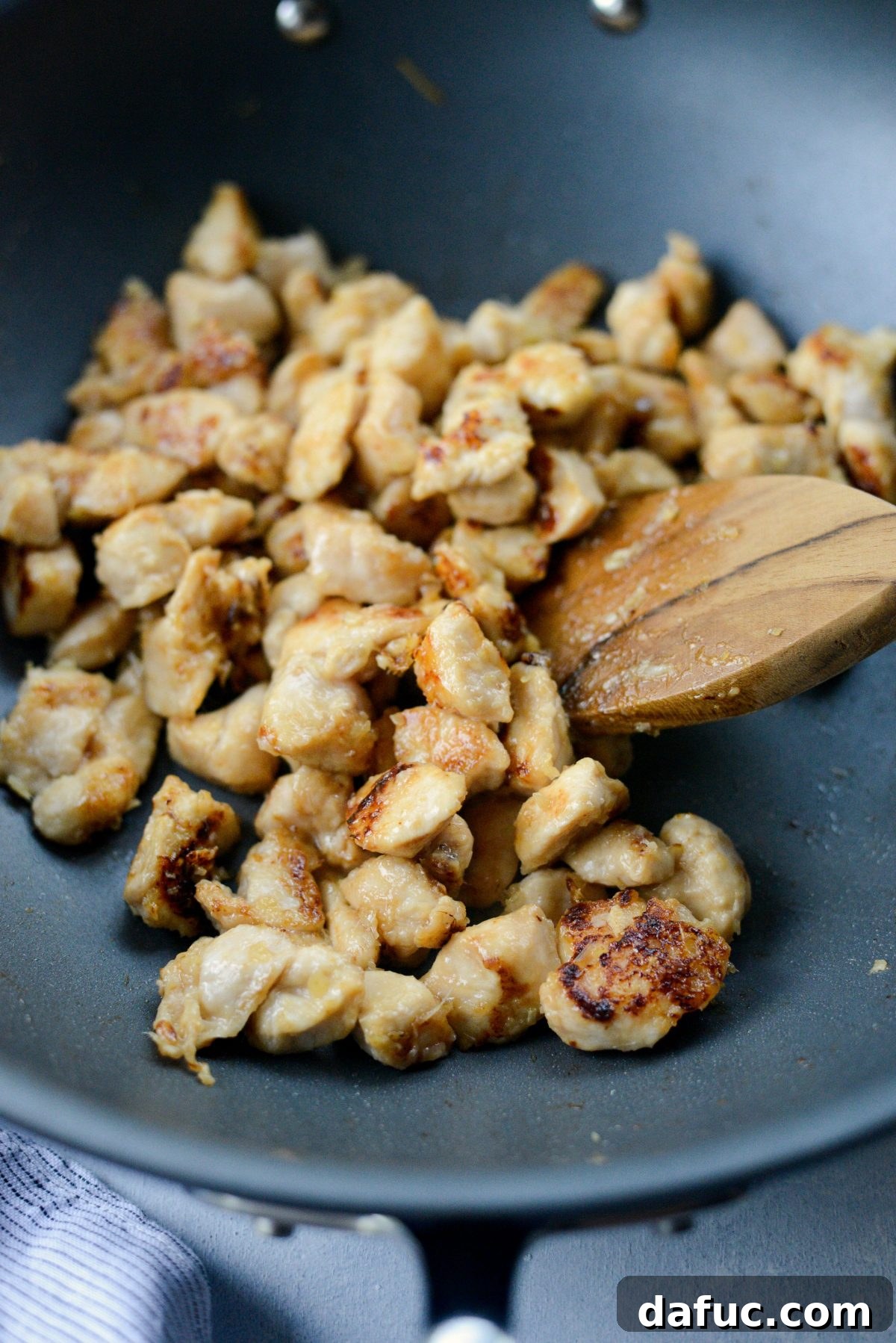 Cooking chicken in the wok until deeply golden and crispy.
