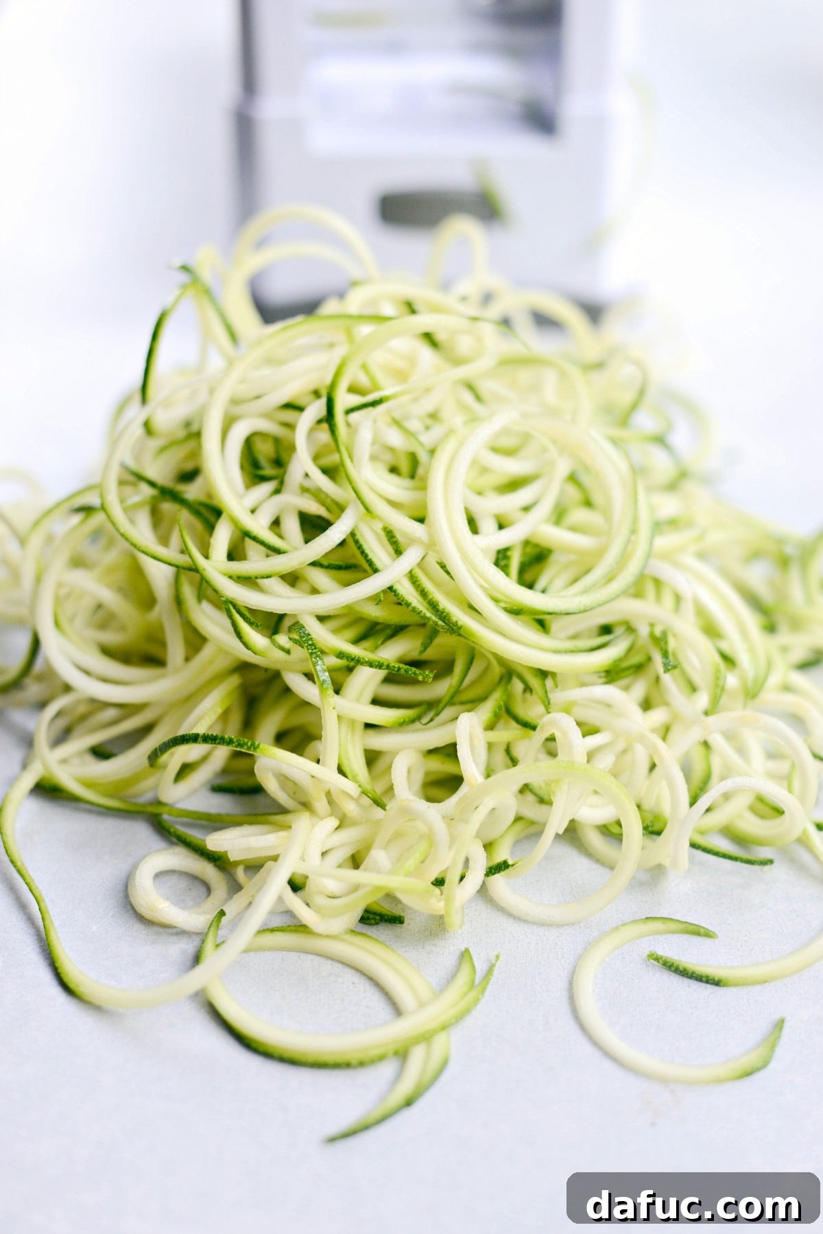 Heap of raw zucchini noodles freshly made and ready for cooking
