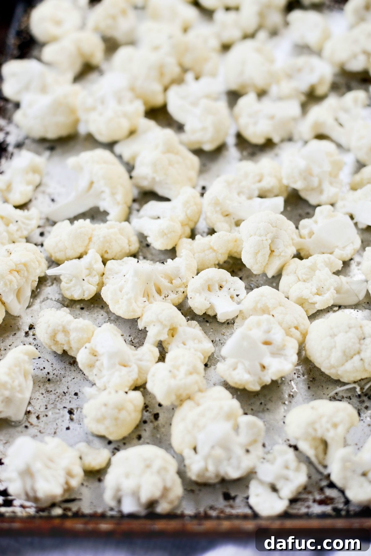 Shawarma Roasted Cauliflower & Chickpea Bowl 5 Seasoned cauliflower florets on a rimmed baking sheet ready for roasting