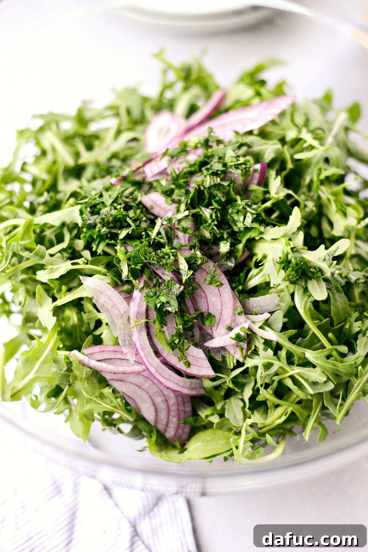 Shawarma Roasted Cauliflower & Chickpea Bowl 10 Baby arugula, sliced red onion, chopped cilantro and parsley in a large mixing bowl
