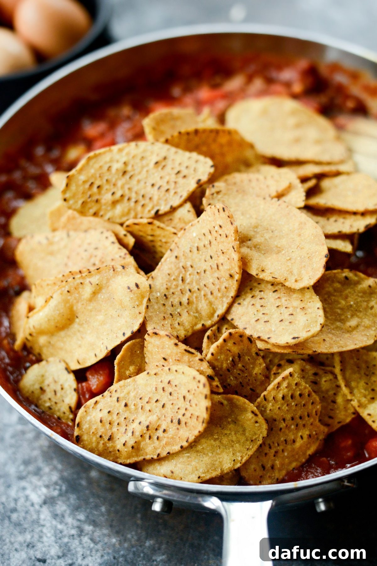 Hearty Chorizo and Sweet Potato Chilaquiles 12 Adding sweet potato chips to the chorizo and tomato sauce mixture