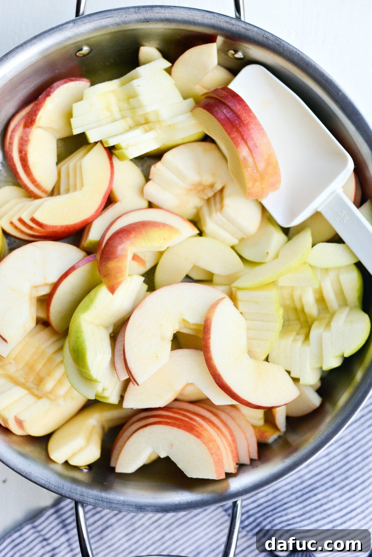 Apple slices added to the hot skillet with butter, beginning to cook