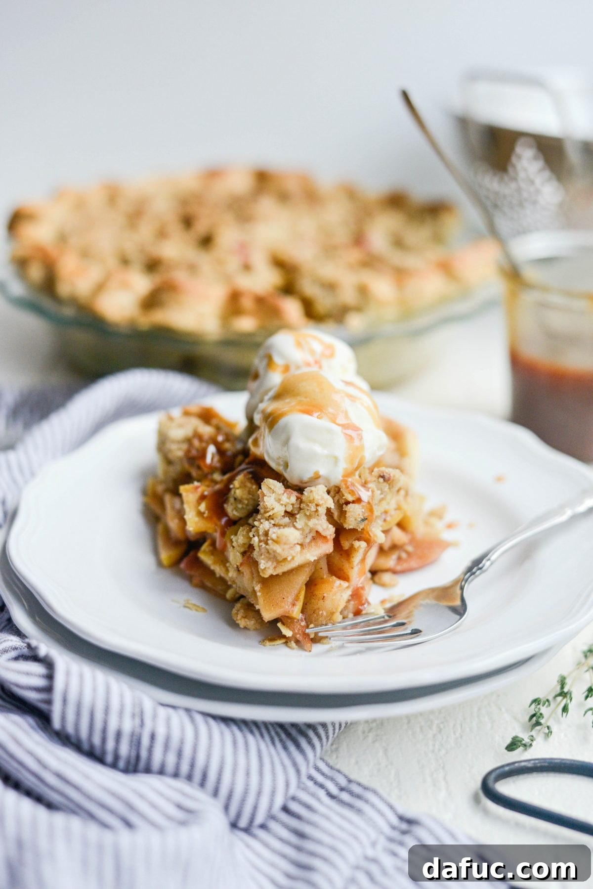 Rustic Brown Sugar Apple Pie with Oatmeal Thyme Crumble, sliced and served with ice cream and caramel
