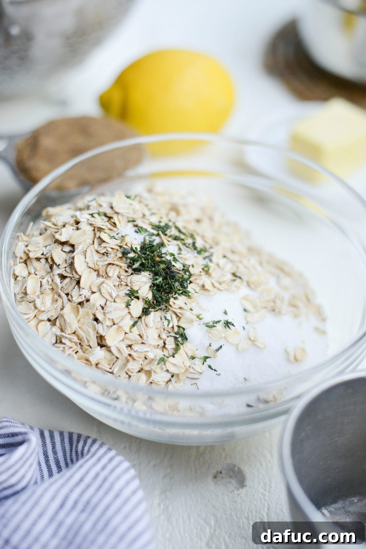 Fresh thyme leaves being added to the dry crumble mixture