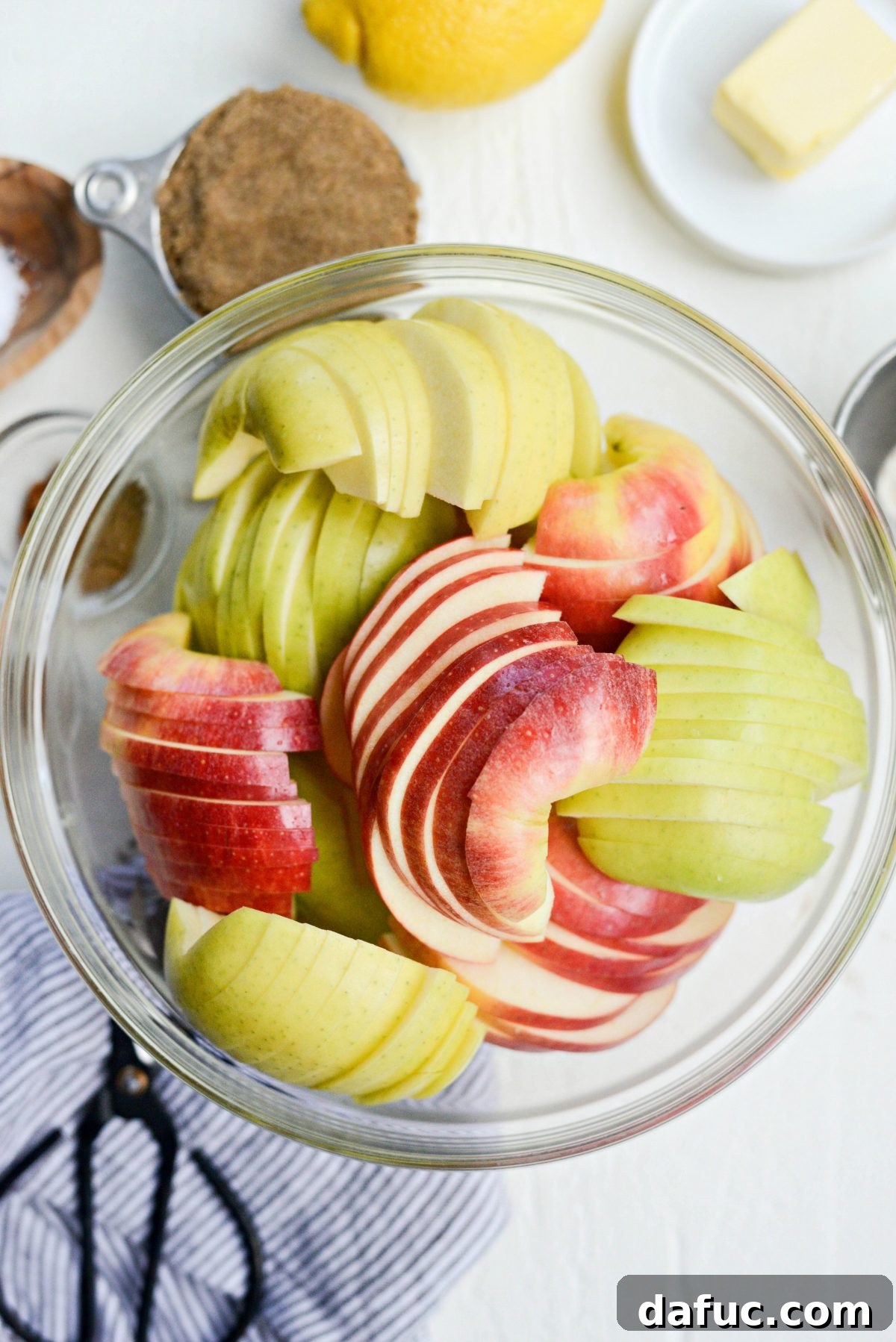 Sliced unpeeled apples in a large bowl, ready for cooking