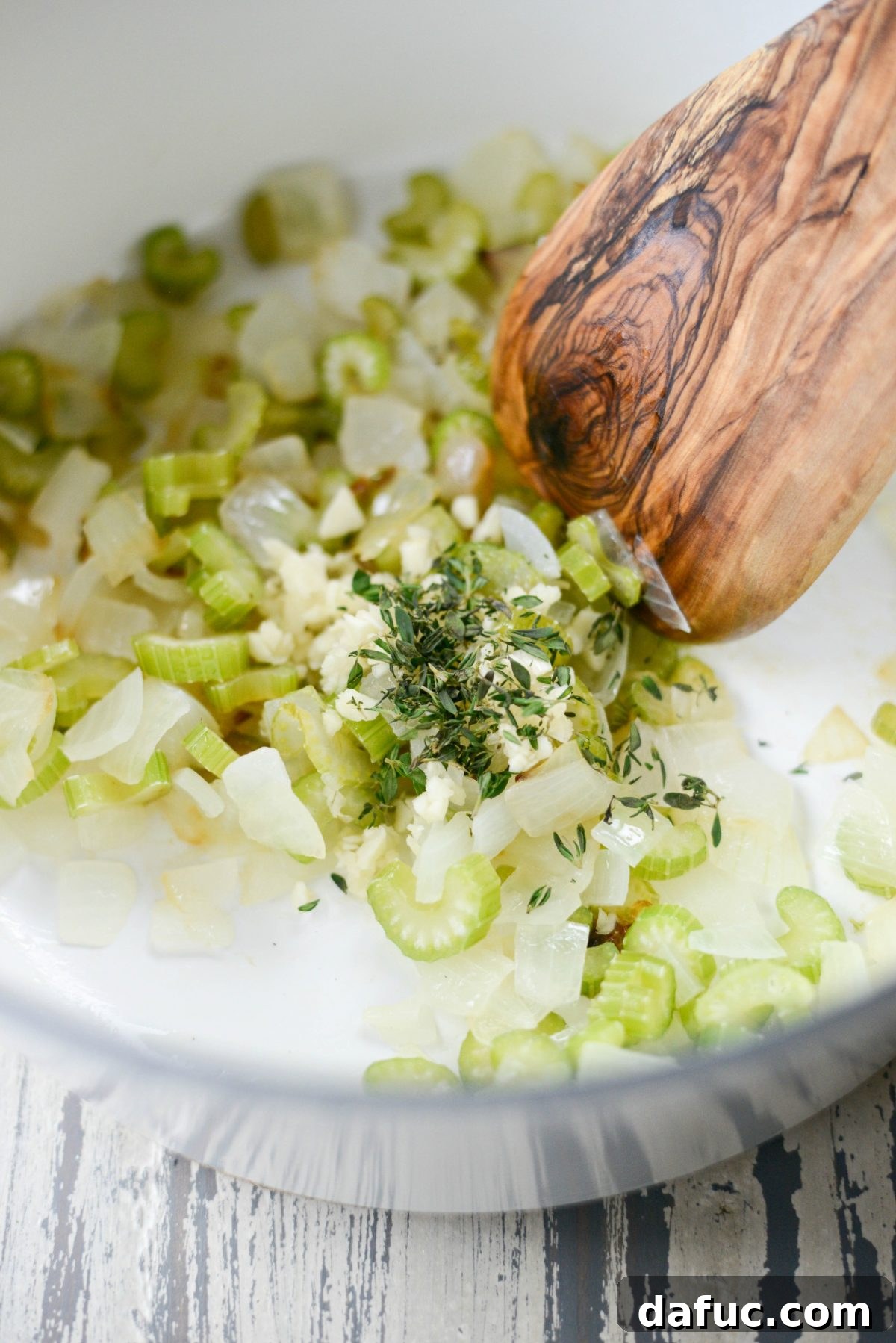 Minced garlic and fresh thyme leaves added to the sautéed onions and celery in the Dutch oven.