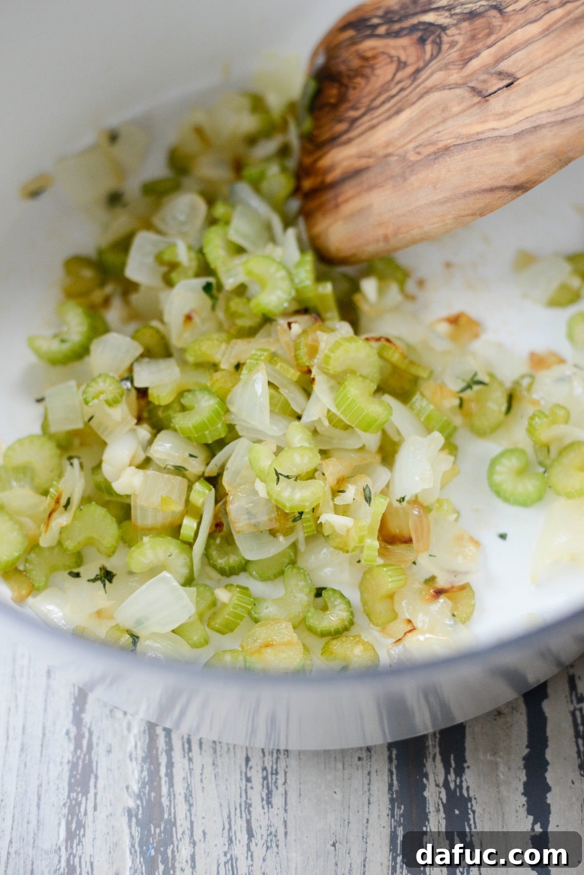 The aromatic blend of sautéed onions, celery, garlic, and thyme simmering gently in the Dutch oven.